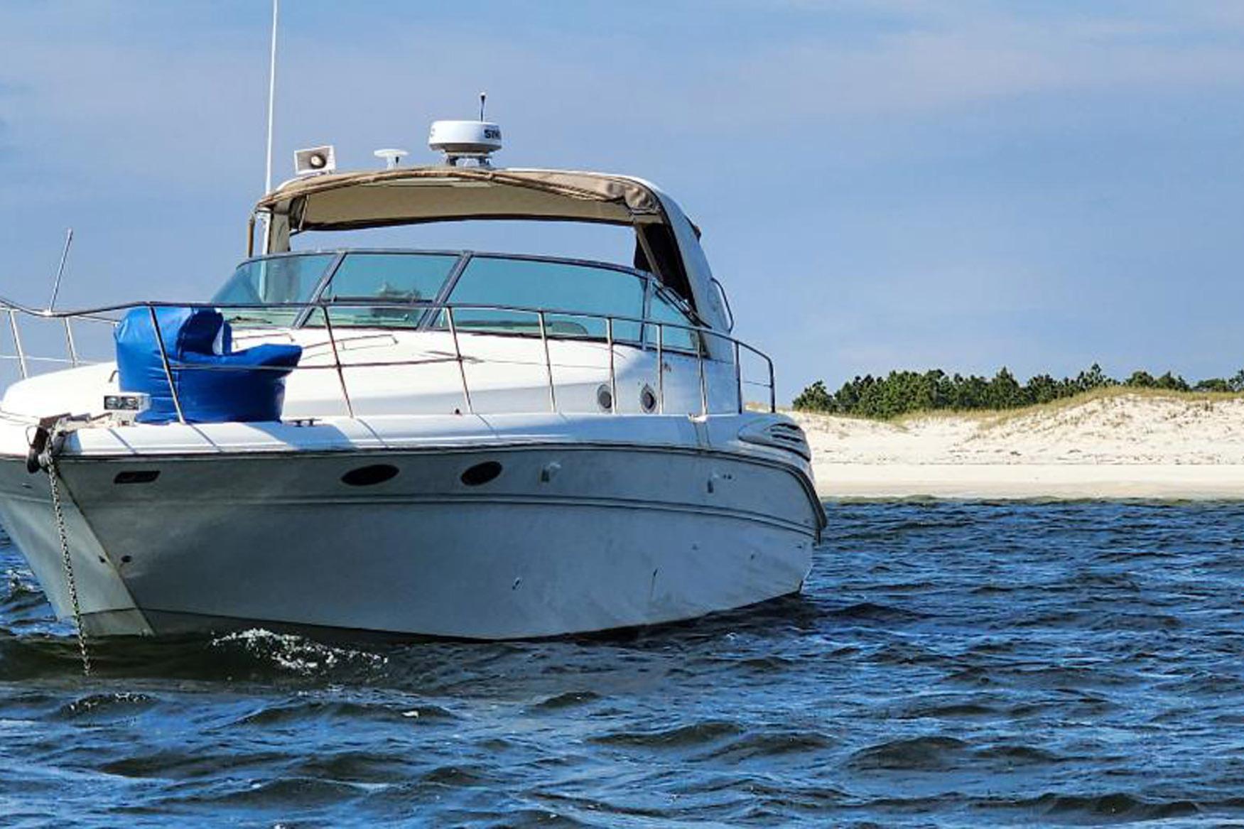 1998 Sea Ray Sundancer 400 yacht anchored near sandy beach, clear blue sky.