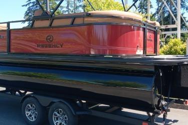 2026 Regency 250 DL pontoon boat on trailer, featuring sleek design and vibrant red color.