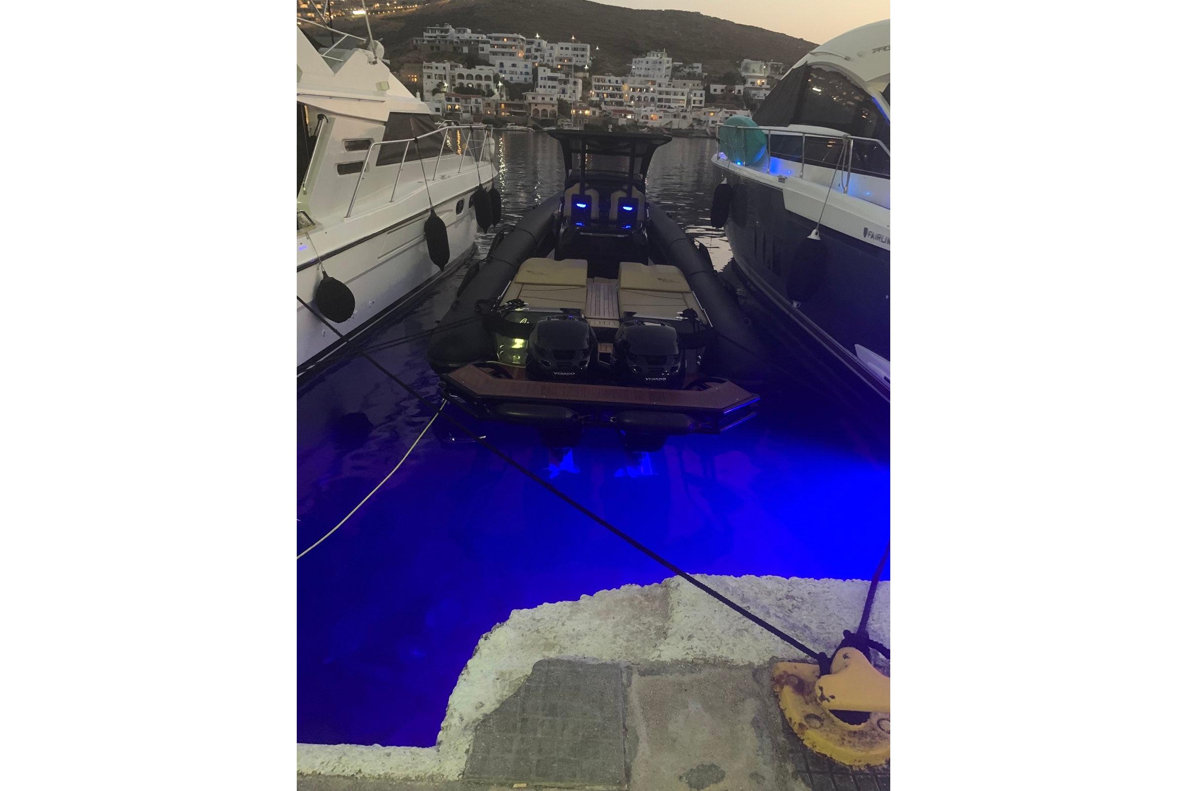 Ribco Seafarer 36 X 2020 docked at night with blue underwater lights.