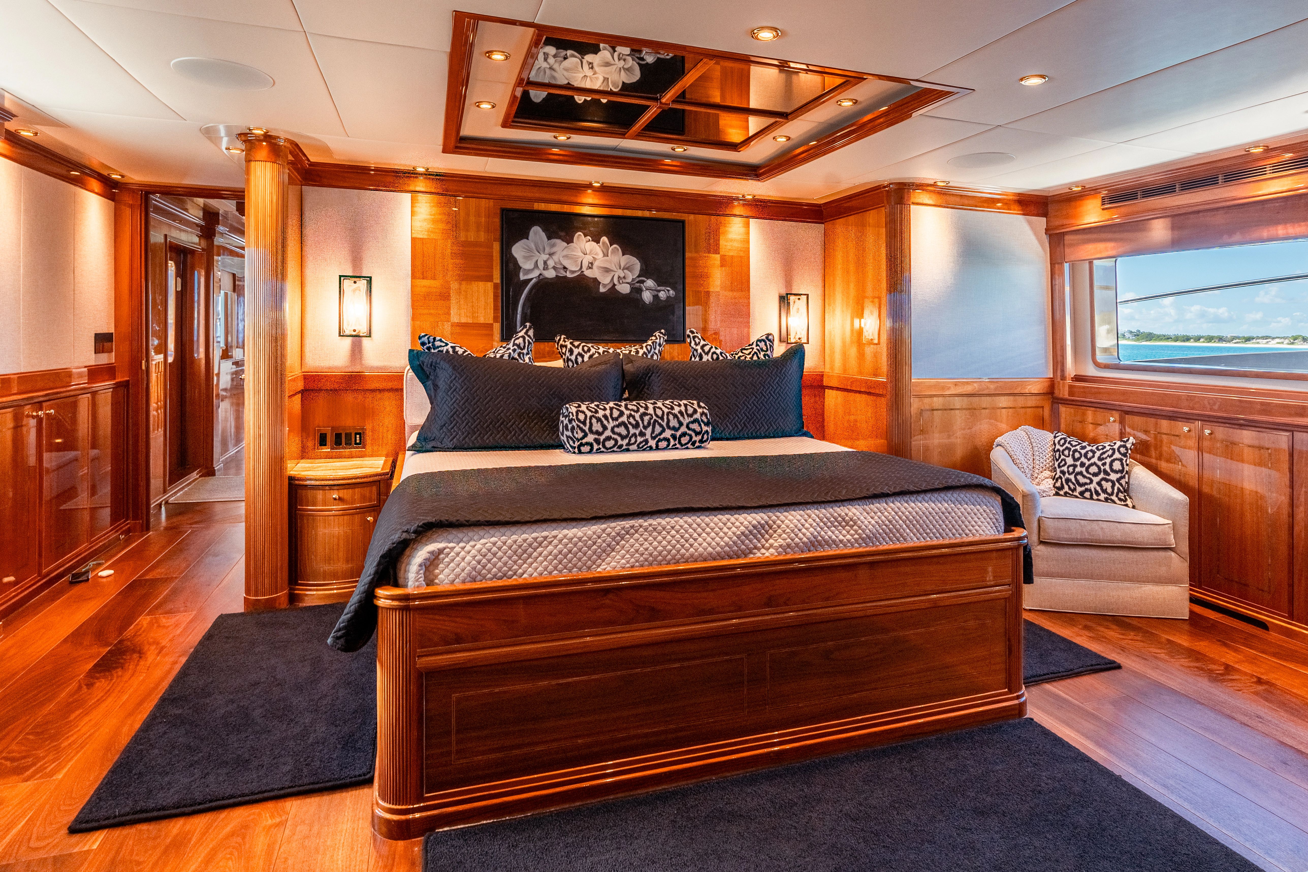 Luxurious bedroom with wood paneling and a large bed on a yacht.