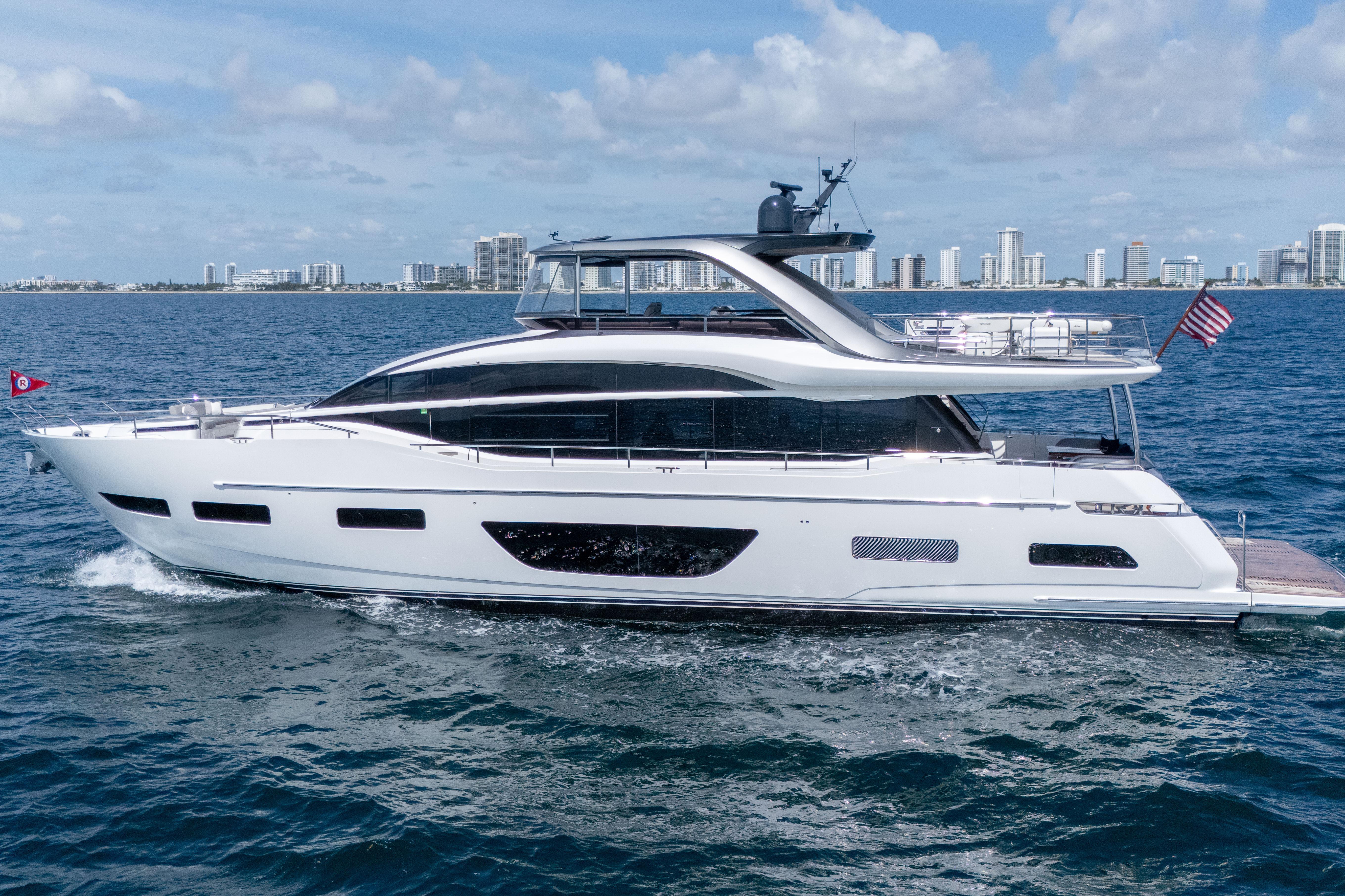 Luxurious 2020 Princess Y85 yacht cruising near a city skyline on a sunny day.