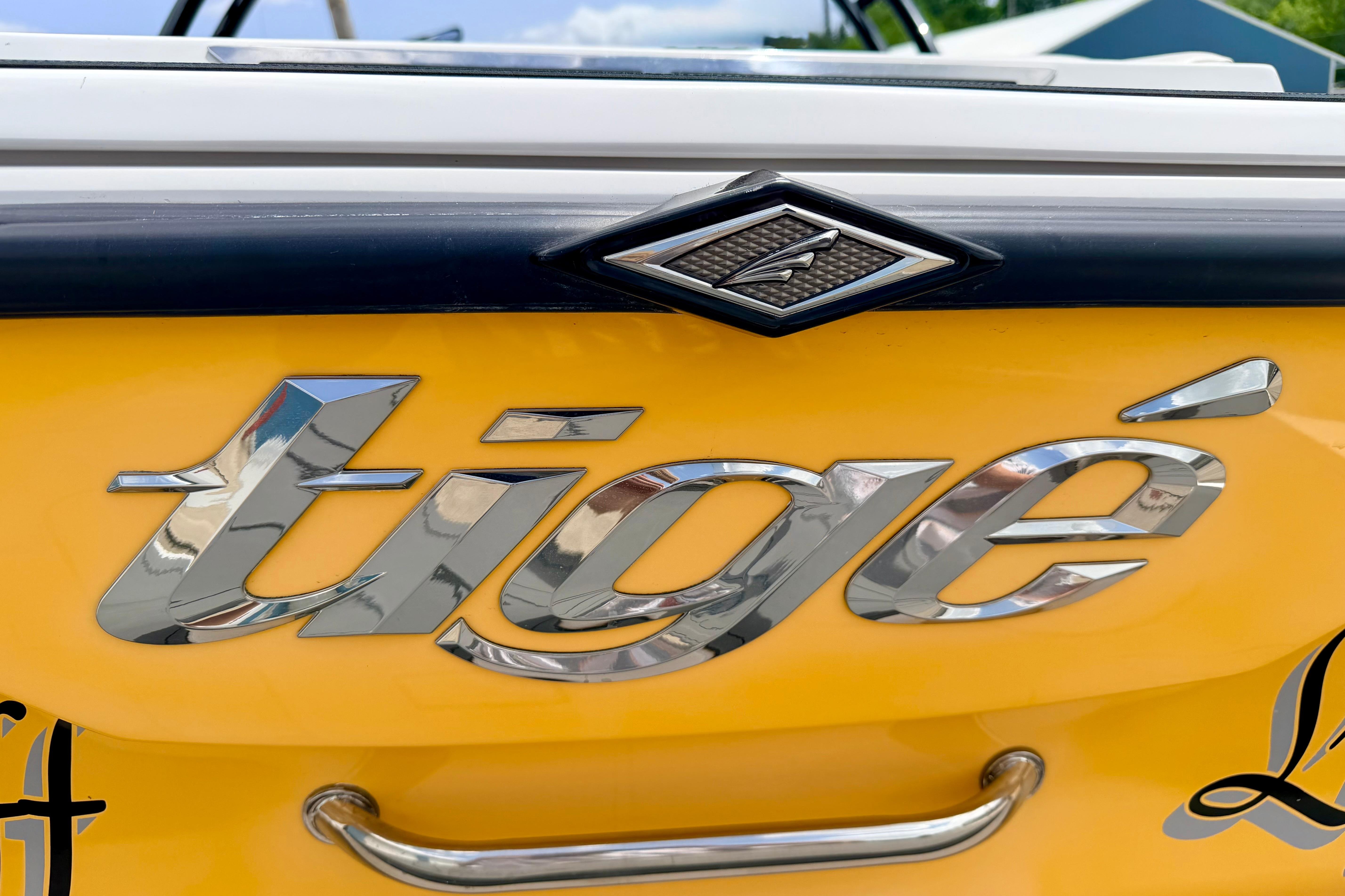 Close-up of 2014 Tigé R20 boat logo on a yellow background.