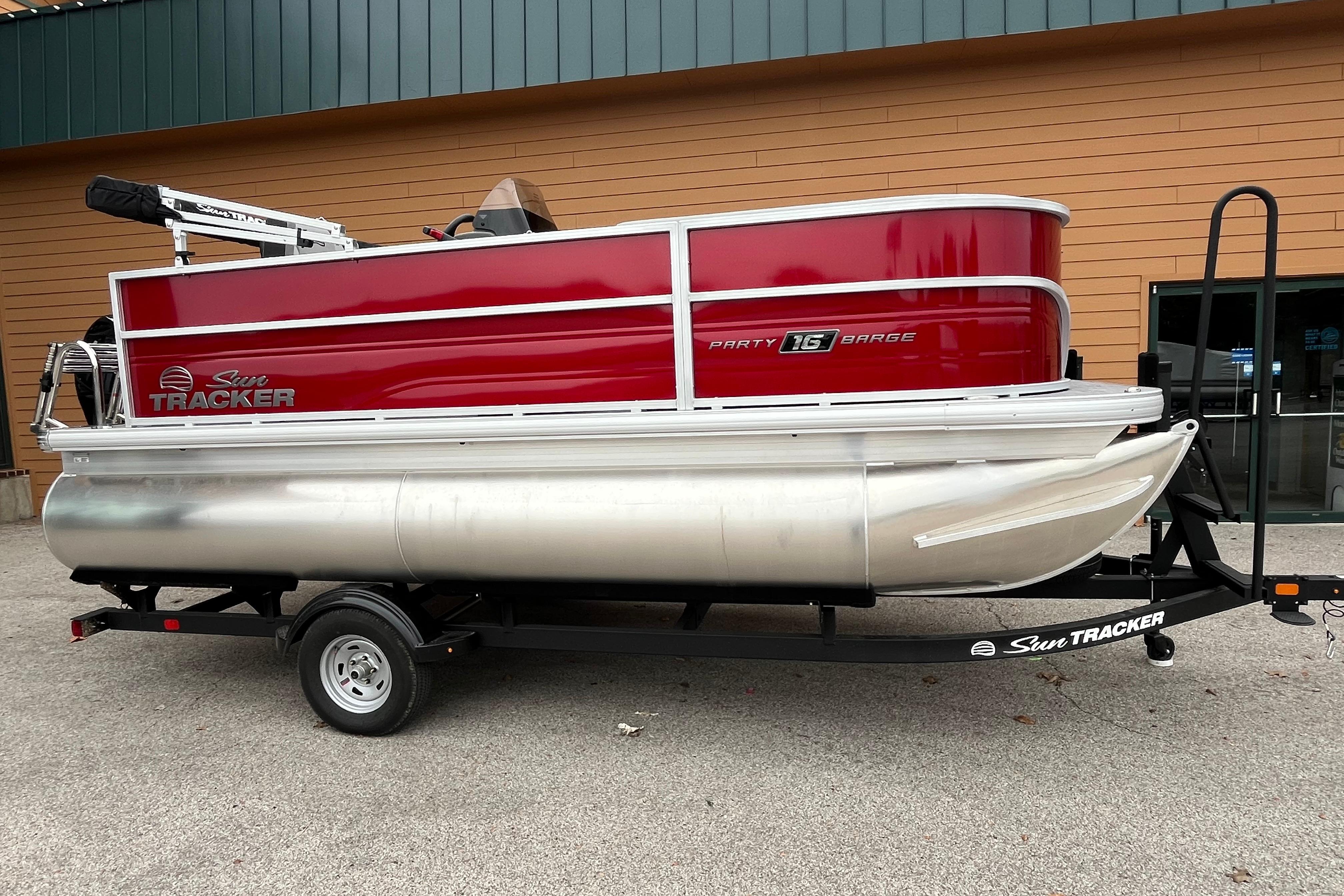 2026 Sun Tracker Party Barge 16 DLX pontoon boat on trailer, red and silver design.