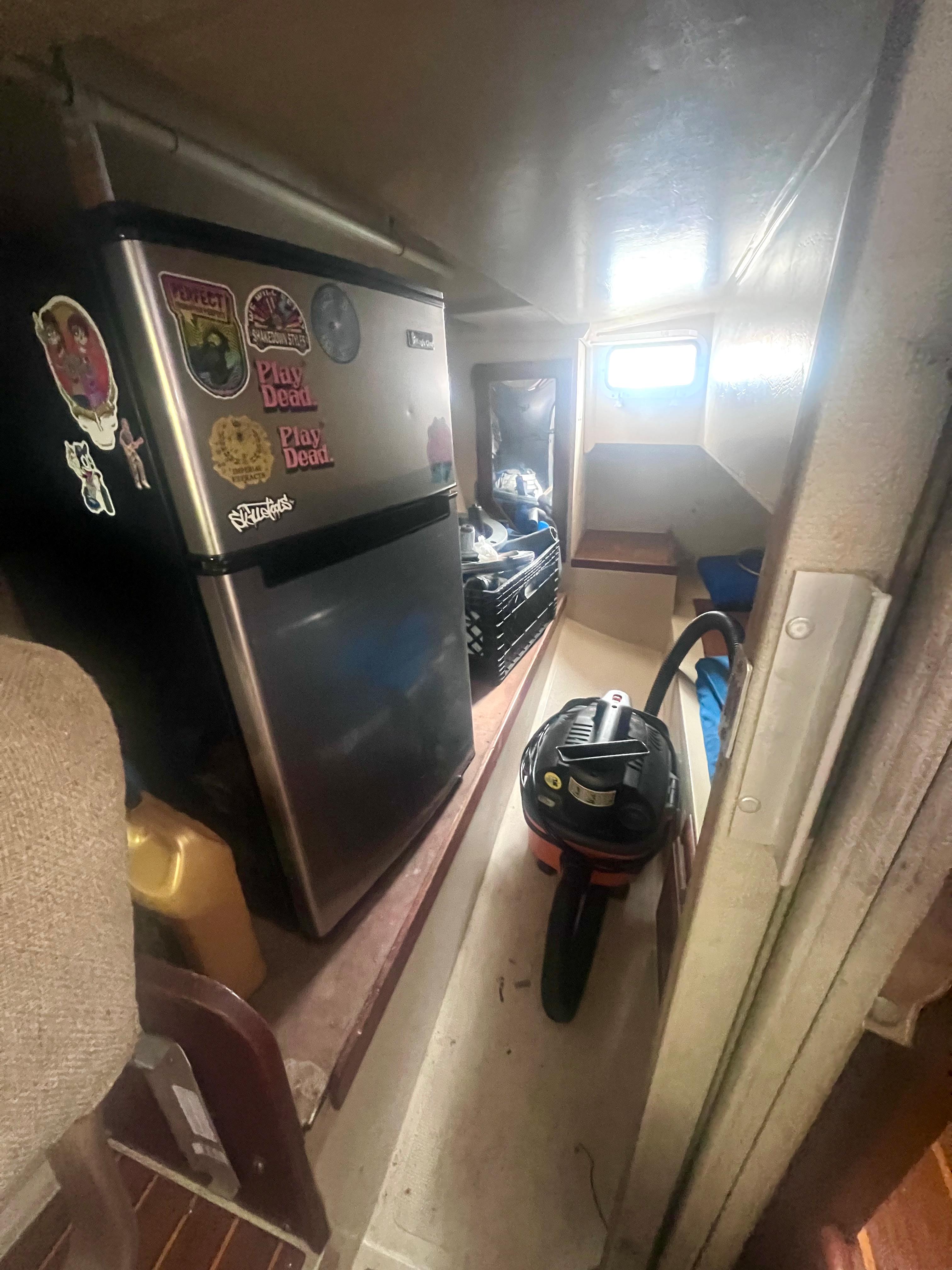 1983 Catalina 36 interior with mini fridge, vacuum, and storage space.