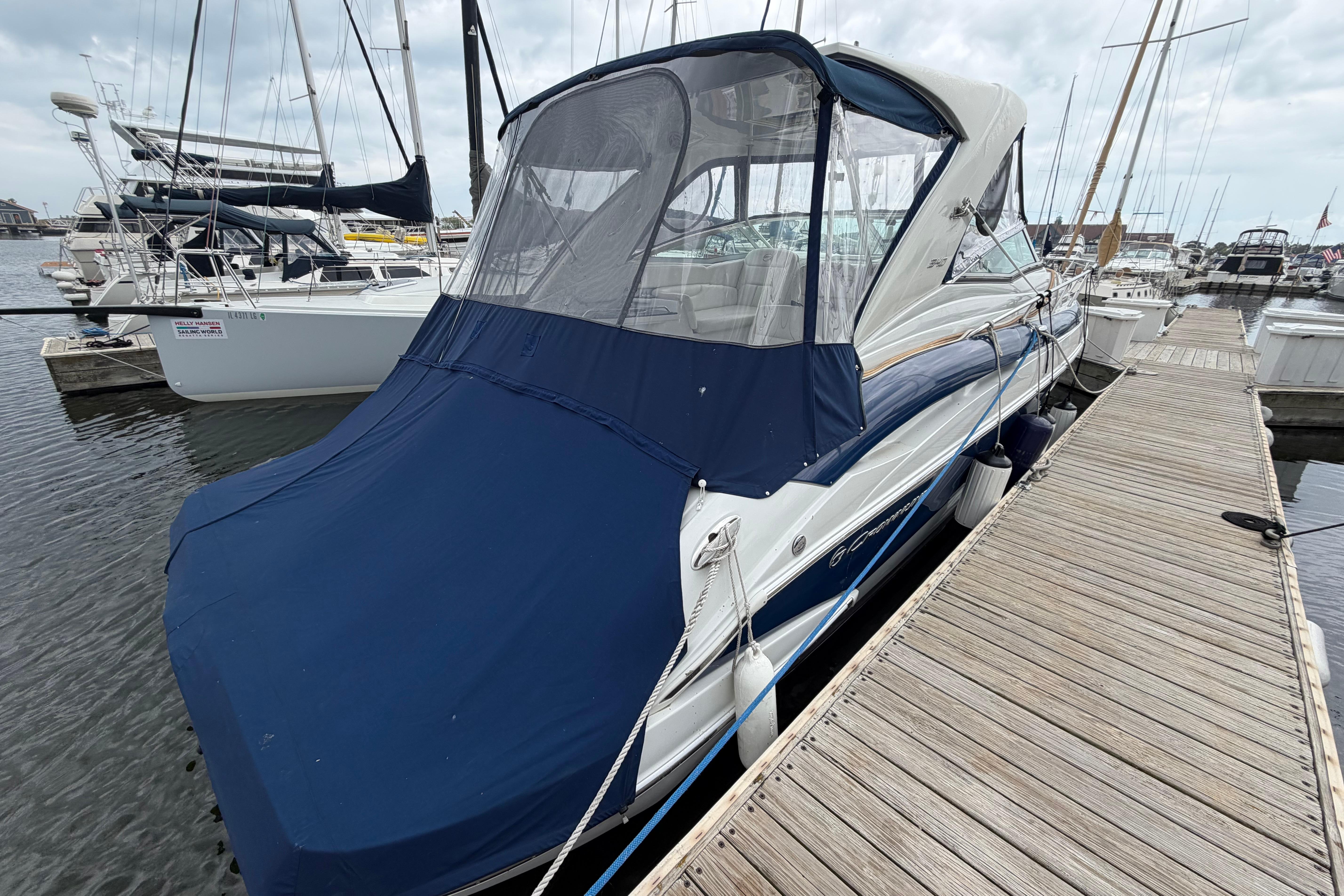 2008 Crownline 340 CR boat docked with blue cover in marina.