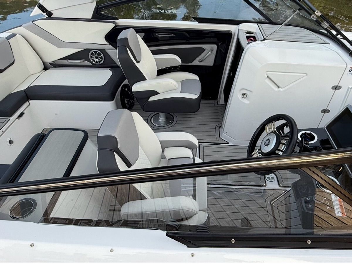 The image shows the cockpit of a 2023 Yamaha Boats 252SD with modern seating and controls.