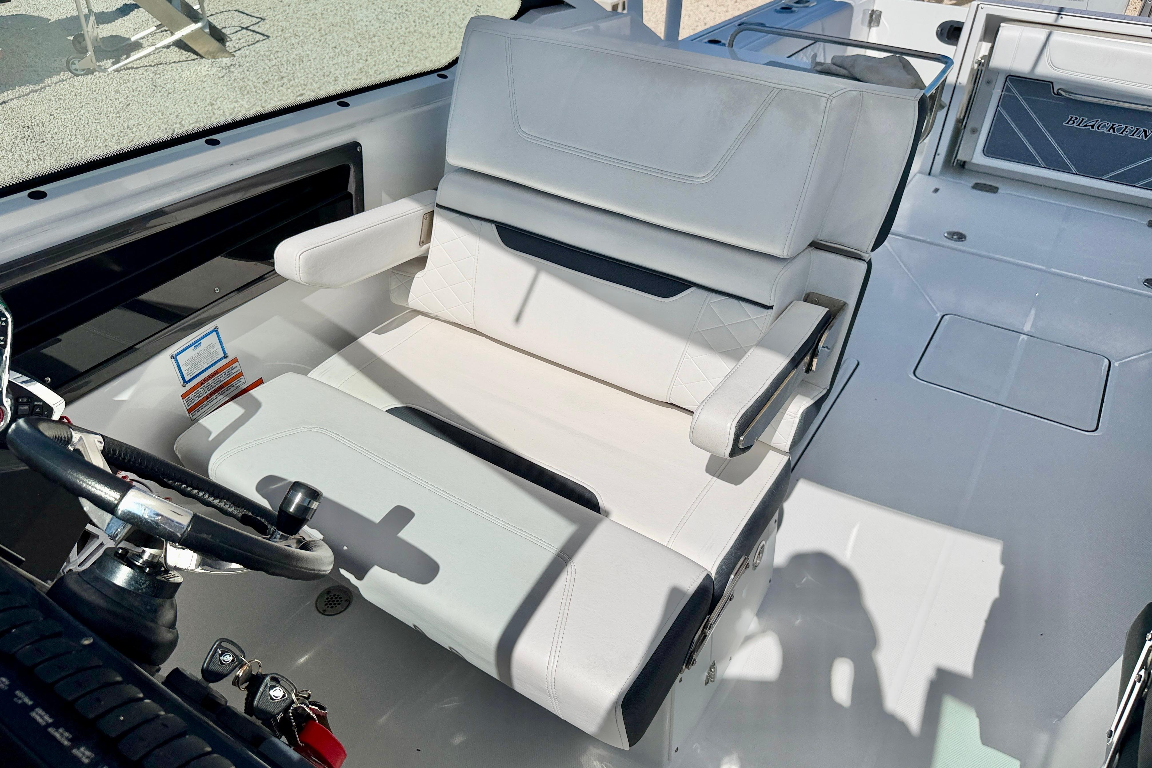 2023 Blackfin 272 DC boat interior with white seating and steering wheel.
