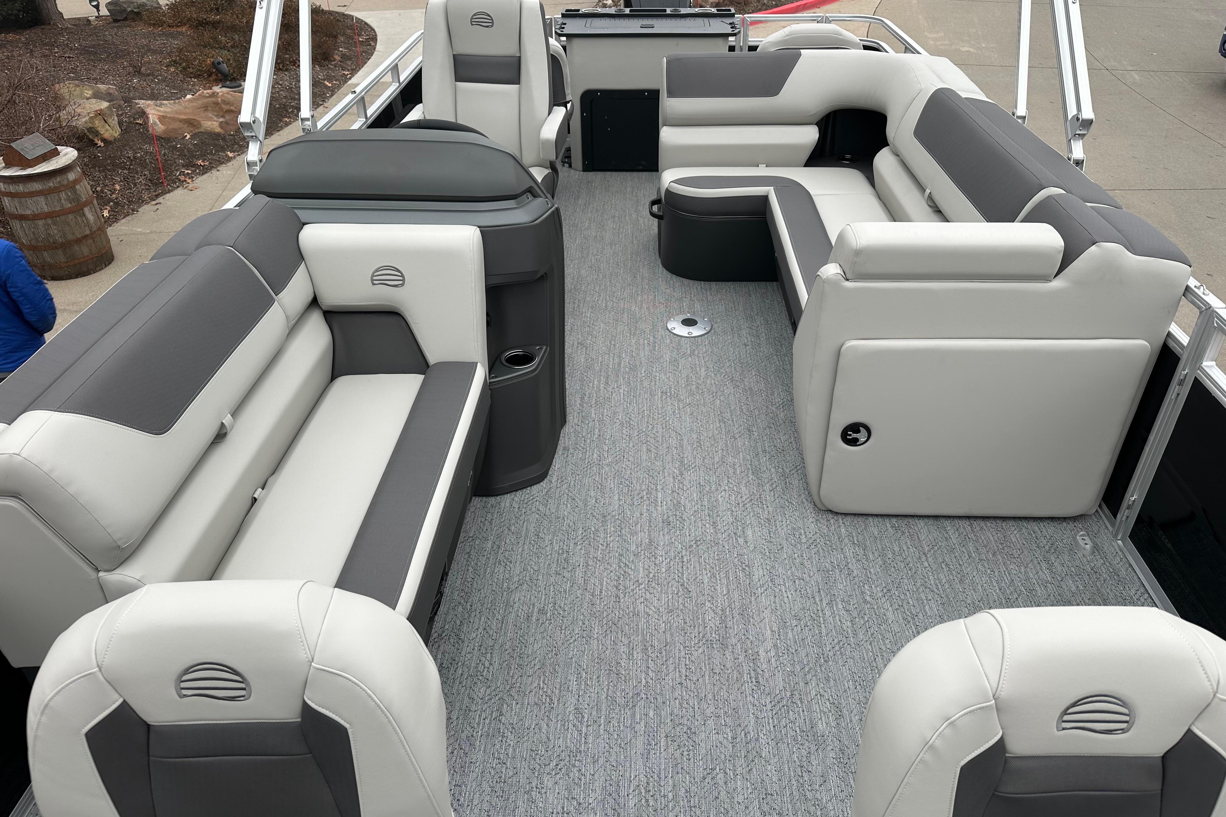 2026 Sun Tracker Fishin' Barge 22 DLX interior with gray seating and carpeted floor.
