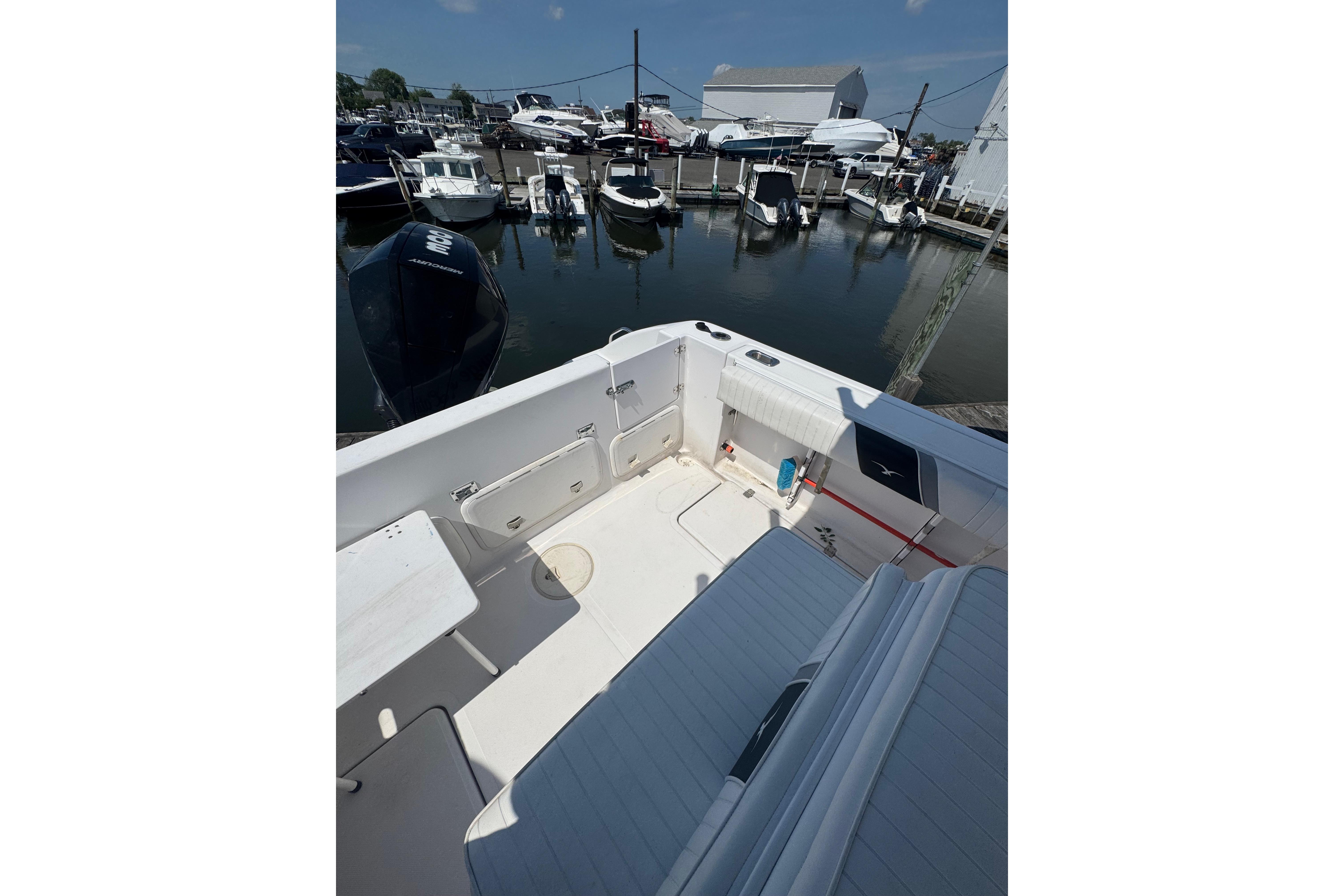 2002 Pro-Line 23 Sport boat docked at a marina, showcasing spacious deck area.