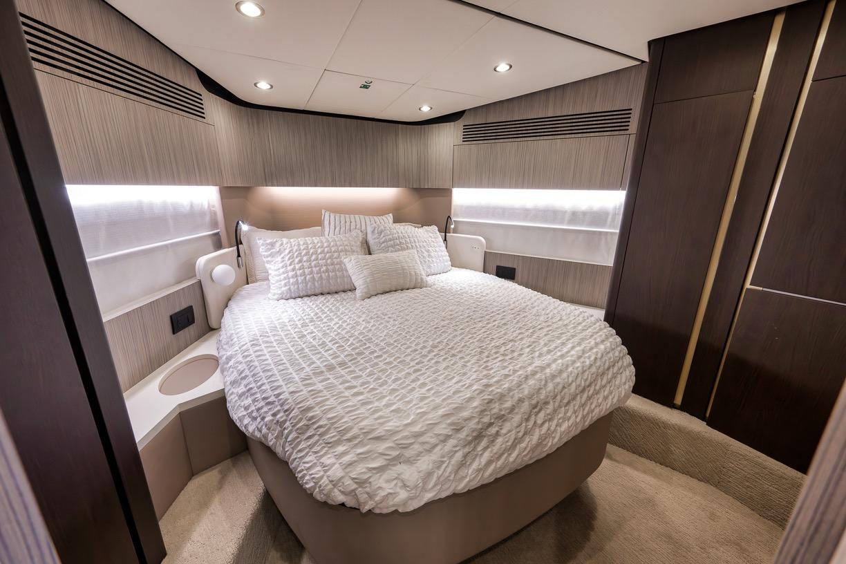 Luxurious bedroom interior of 2019 Azimut 55 yacht with elegant bedding and modern design.