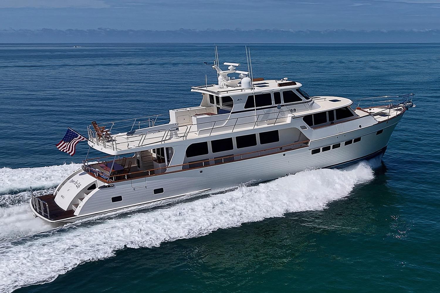 Luxurious 2014 Marlow 80 Explorer yacht cruising on open sea with American flag.