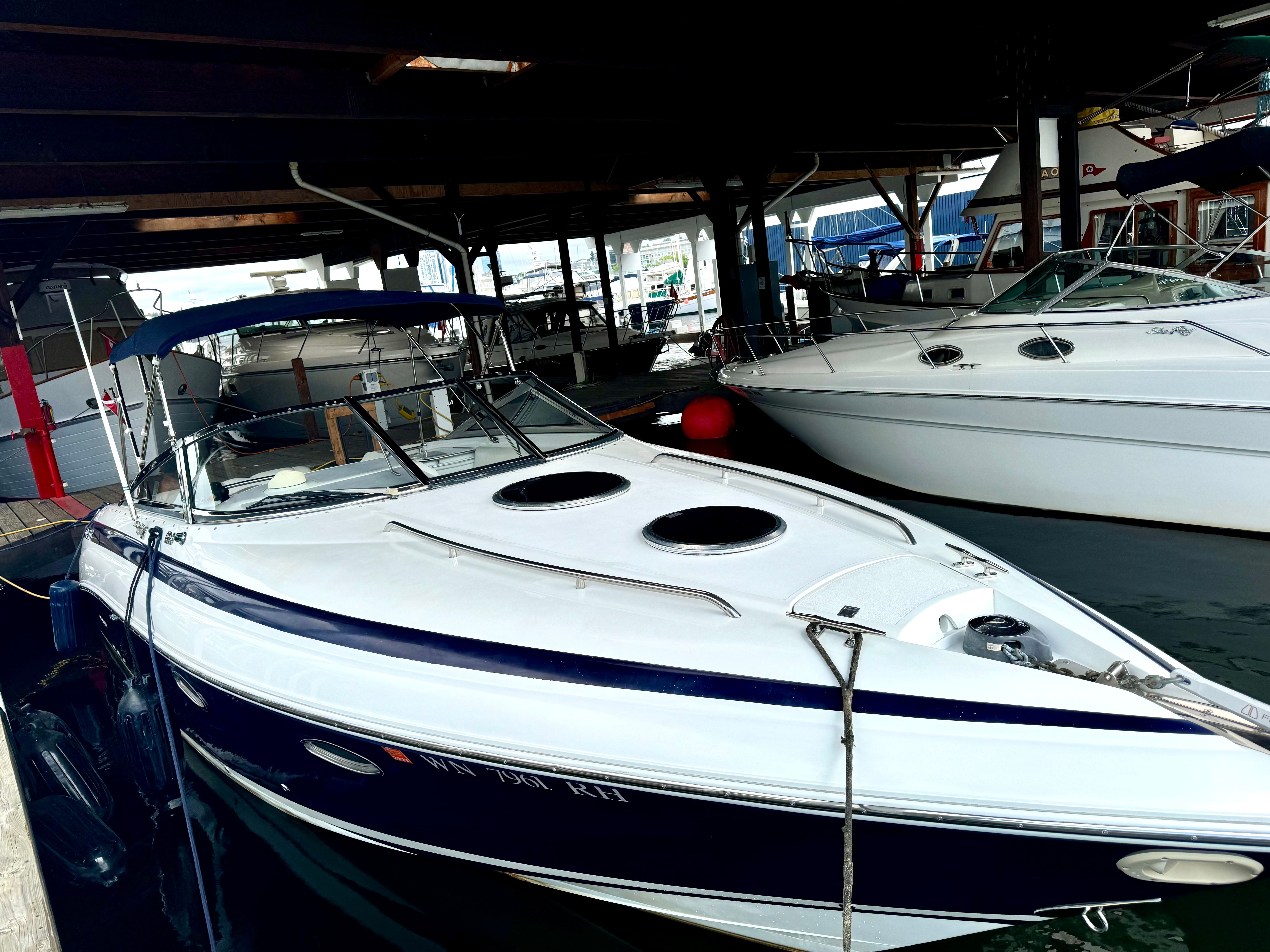 1999 Cobalt 293 boat docked in marina under covered berth.