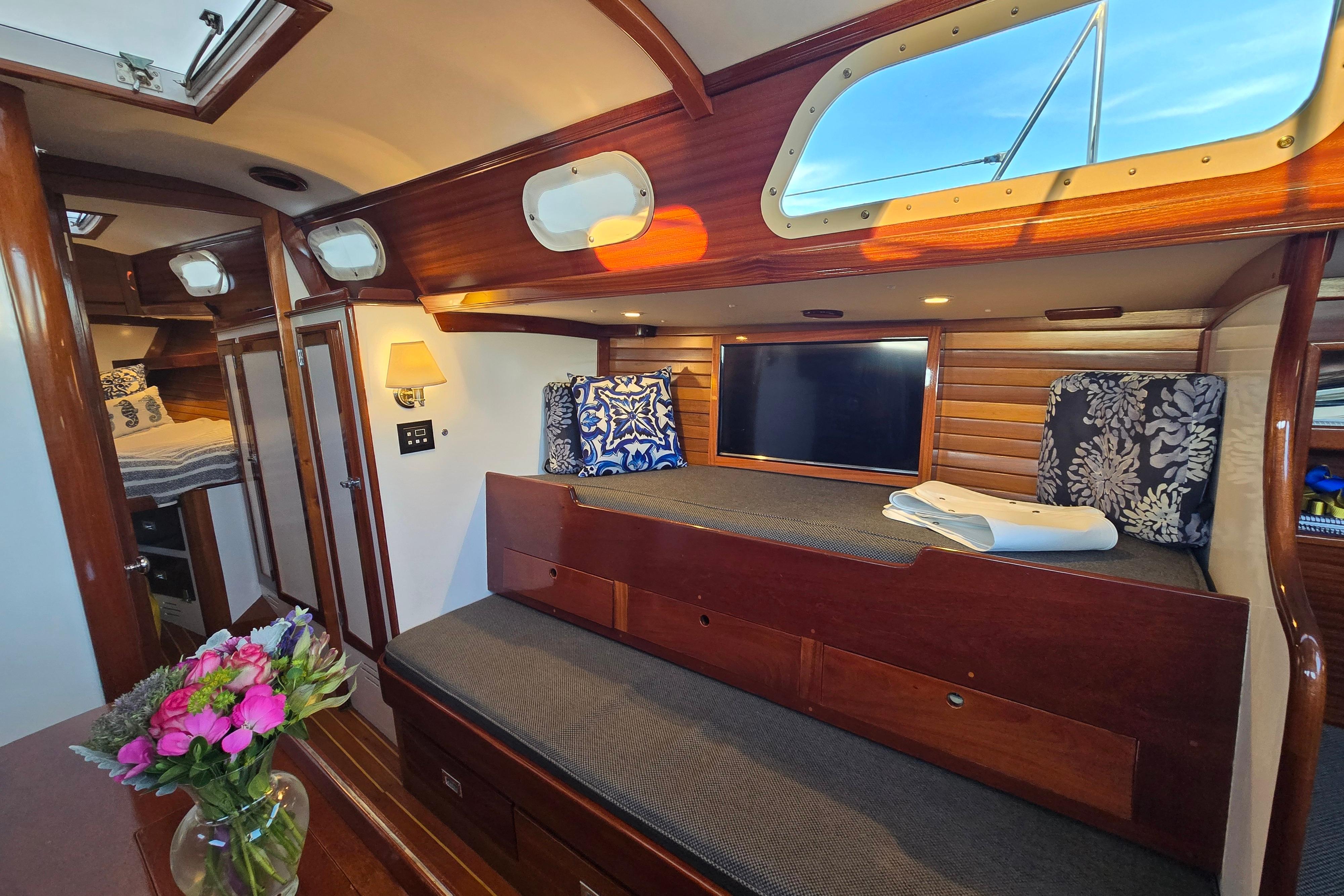 Interior of a 1970 Hinckley Bermuda 40 yacht with cozy seating and elegant wood finishes.