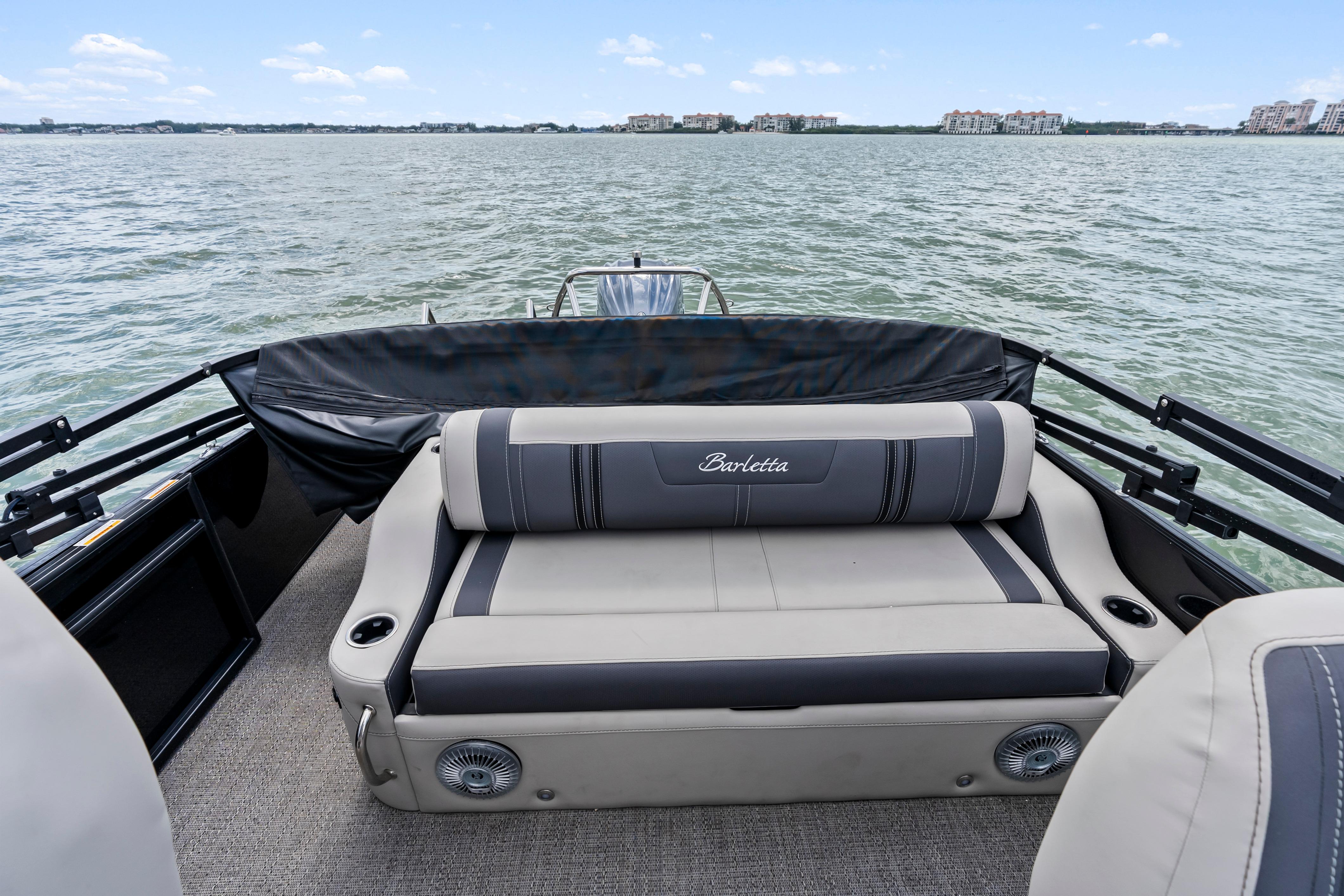 2025 Barletta Corsa 23UC pontoon boat interior with comfortable seating on a lake.