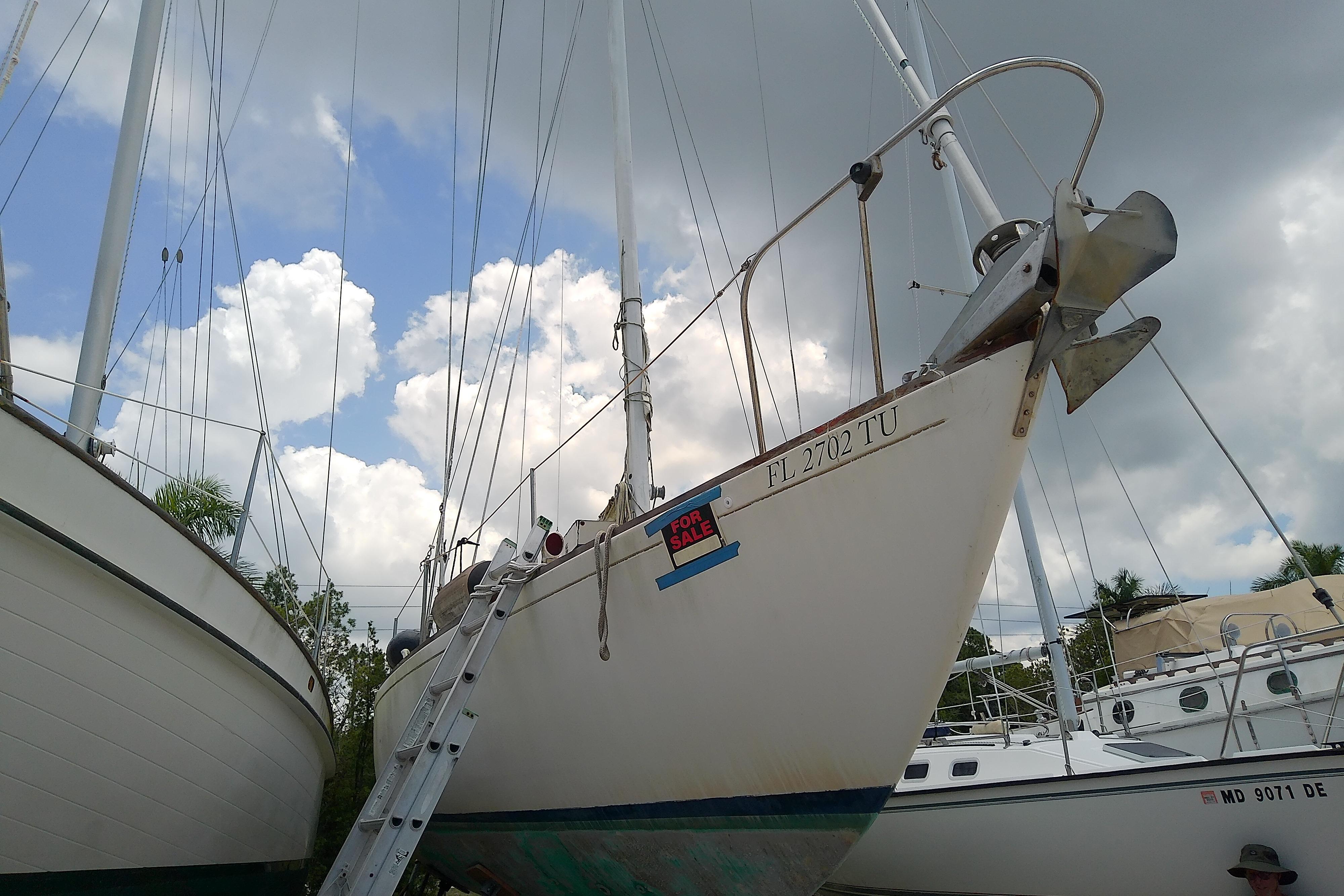 1981 Sea Sprite 34 sailboat on land, for sale, under cloudy sky.
