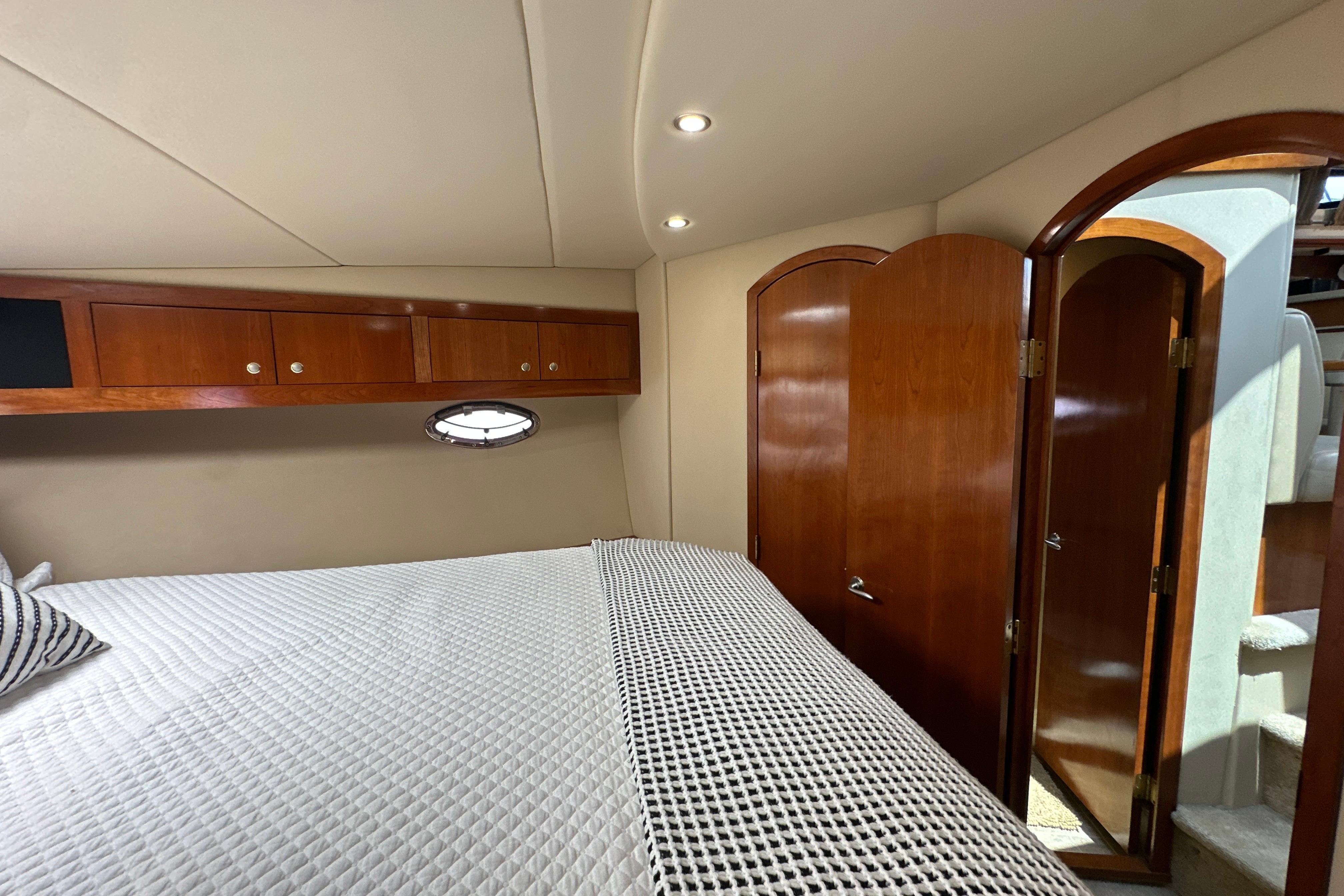 Luxurious cabin interior of 2004 Cruisers Yachts 405 Express Motoryacht with wood accents.