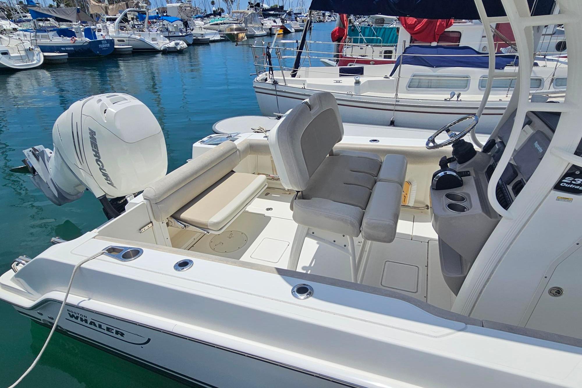 2017 Boston Whaler 230 Outrage boat with Mercury engine, docked in a marina.