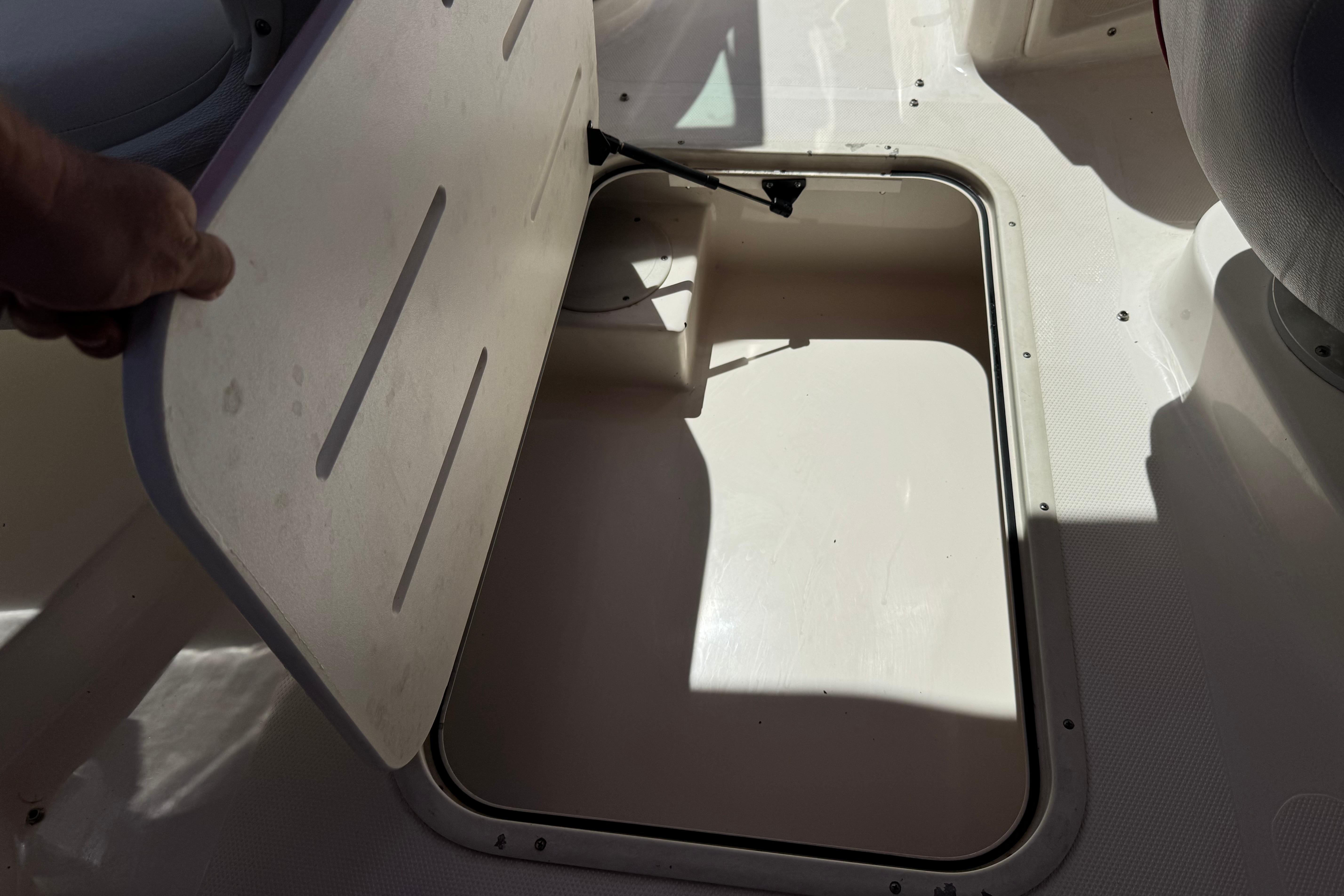 Open storage compartment on a 2010 Bryant 255 boat, showcasing interior space.