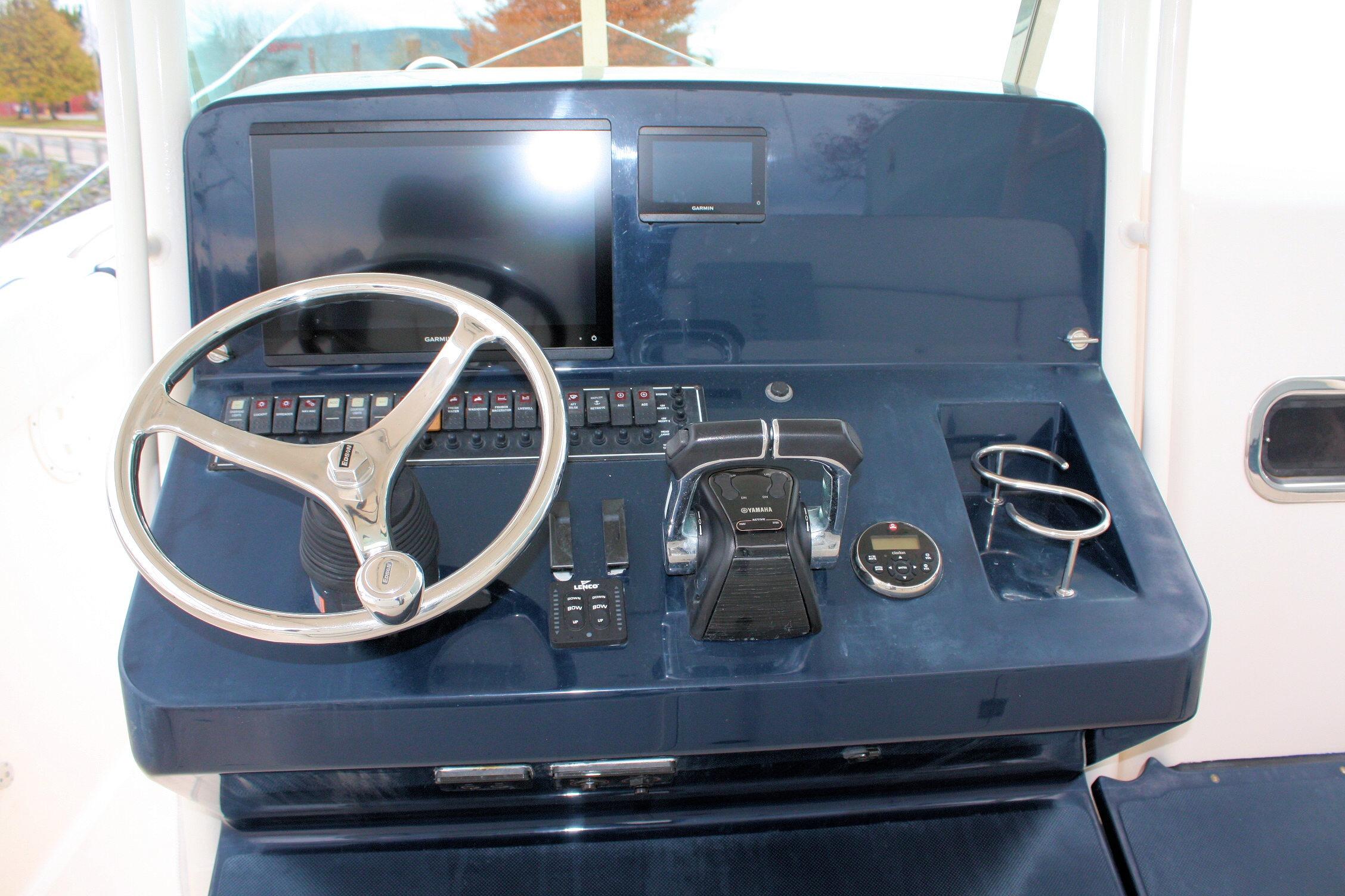 Control panel of 2013 Pursuit ST 310 Sport boat with steering wheel and navigation equipment.