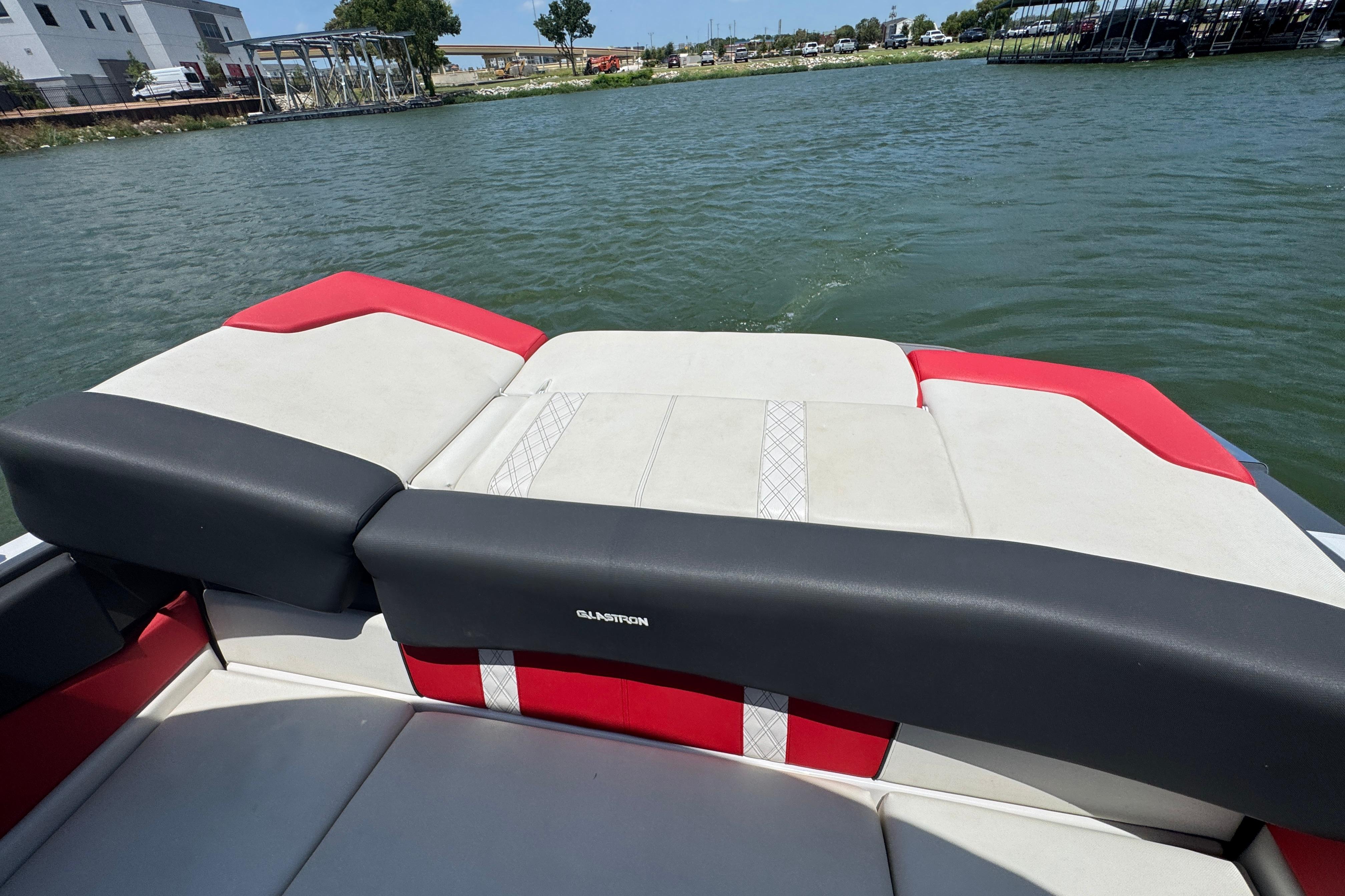 2017 Glastron GT 225 boat interior with red and white seating on a lake.