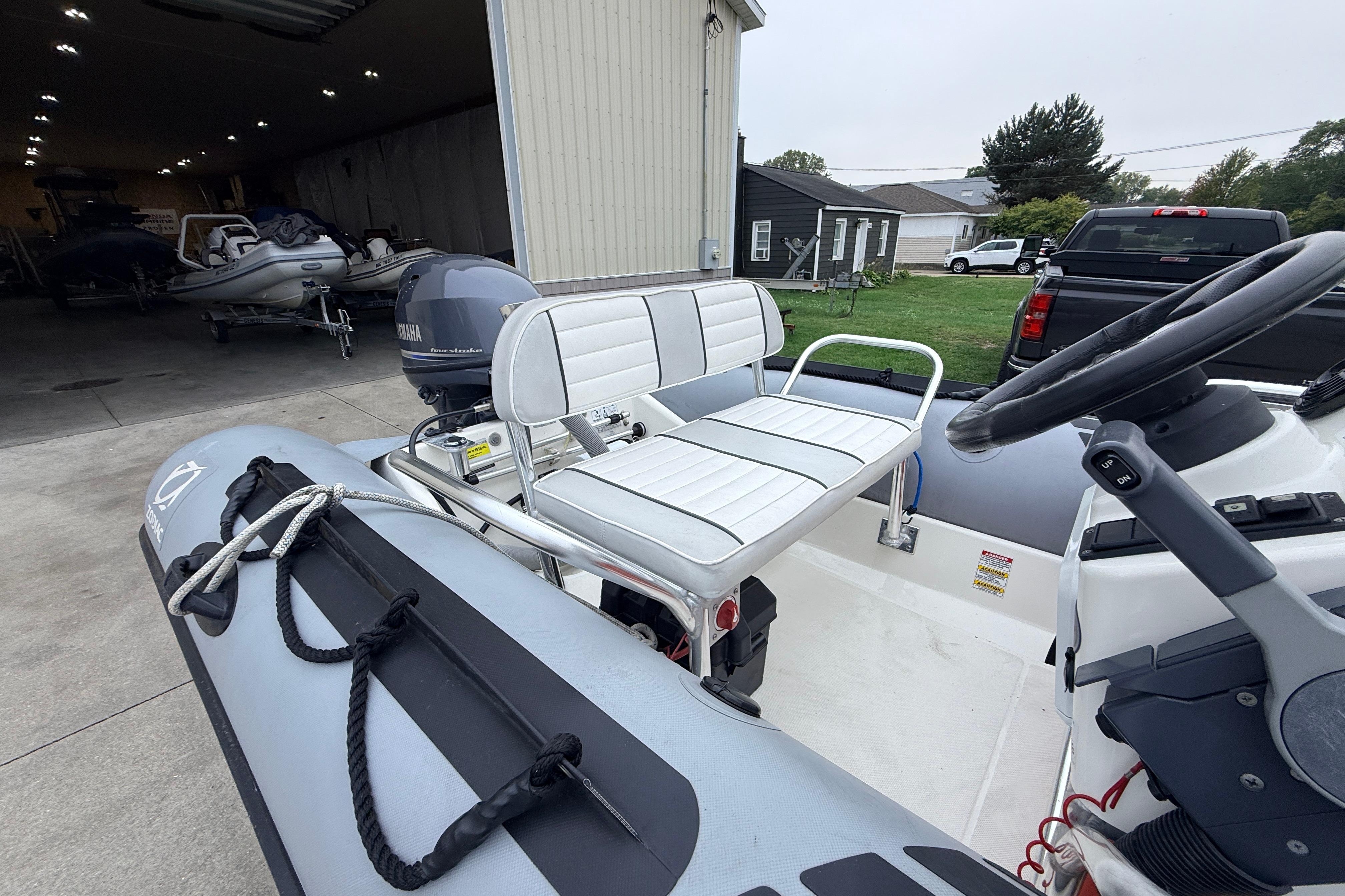 2014 Zodiac Pro Classic 420 inflatable boat with Yamaha motor, parked near a garage.