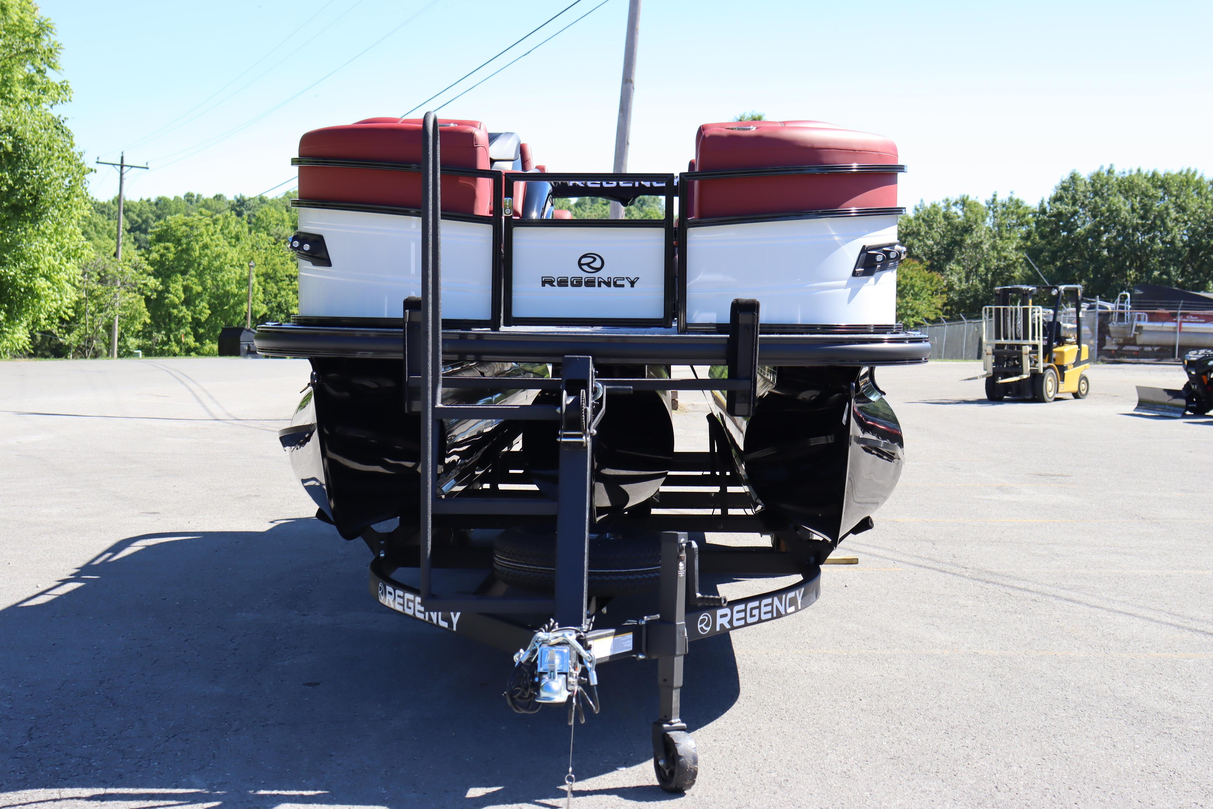 2026 Regency 250 DL pontoon boat on trailer, parked outdoors on a sunny day.