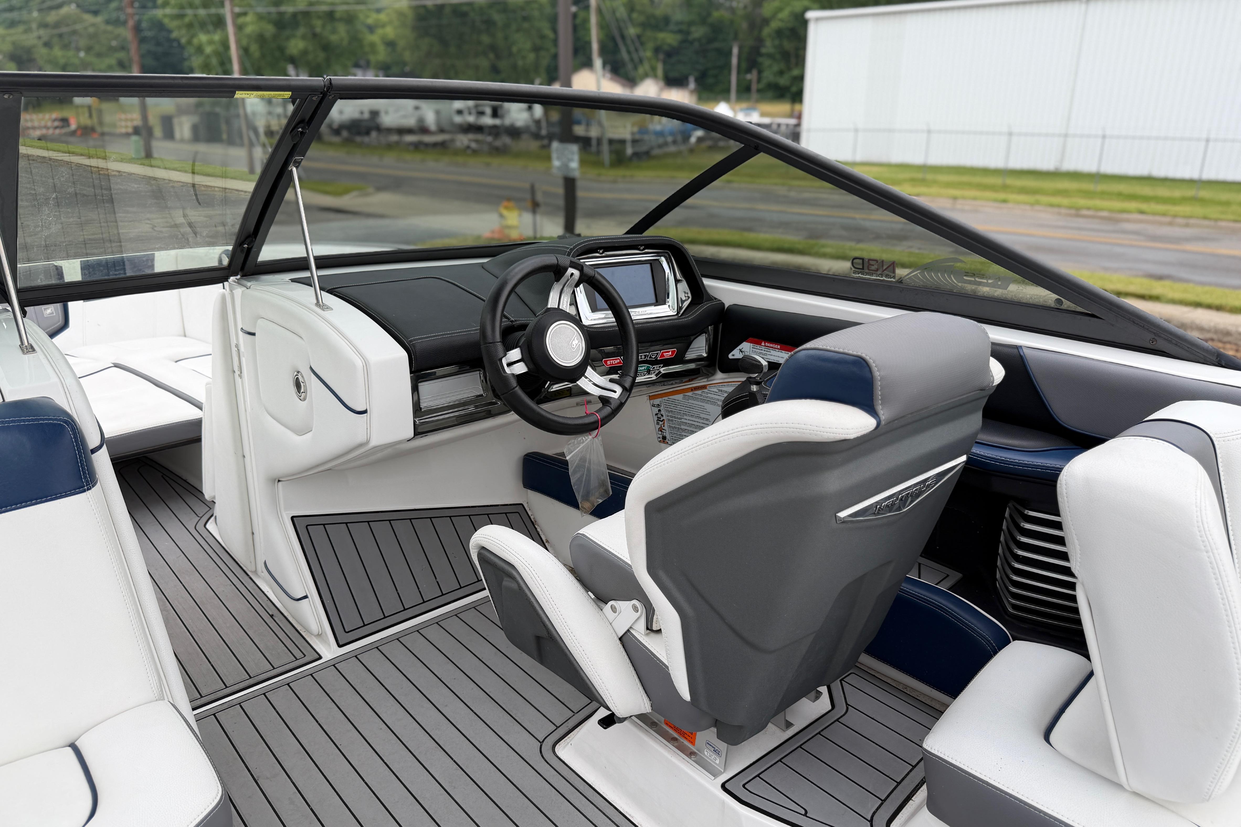 Interior of a 2016 Naitique G25 boat with modern dashboard and seating.