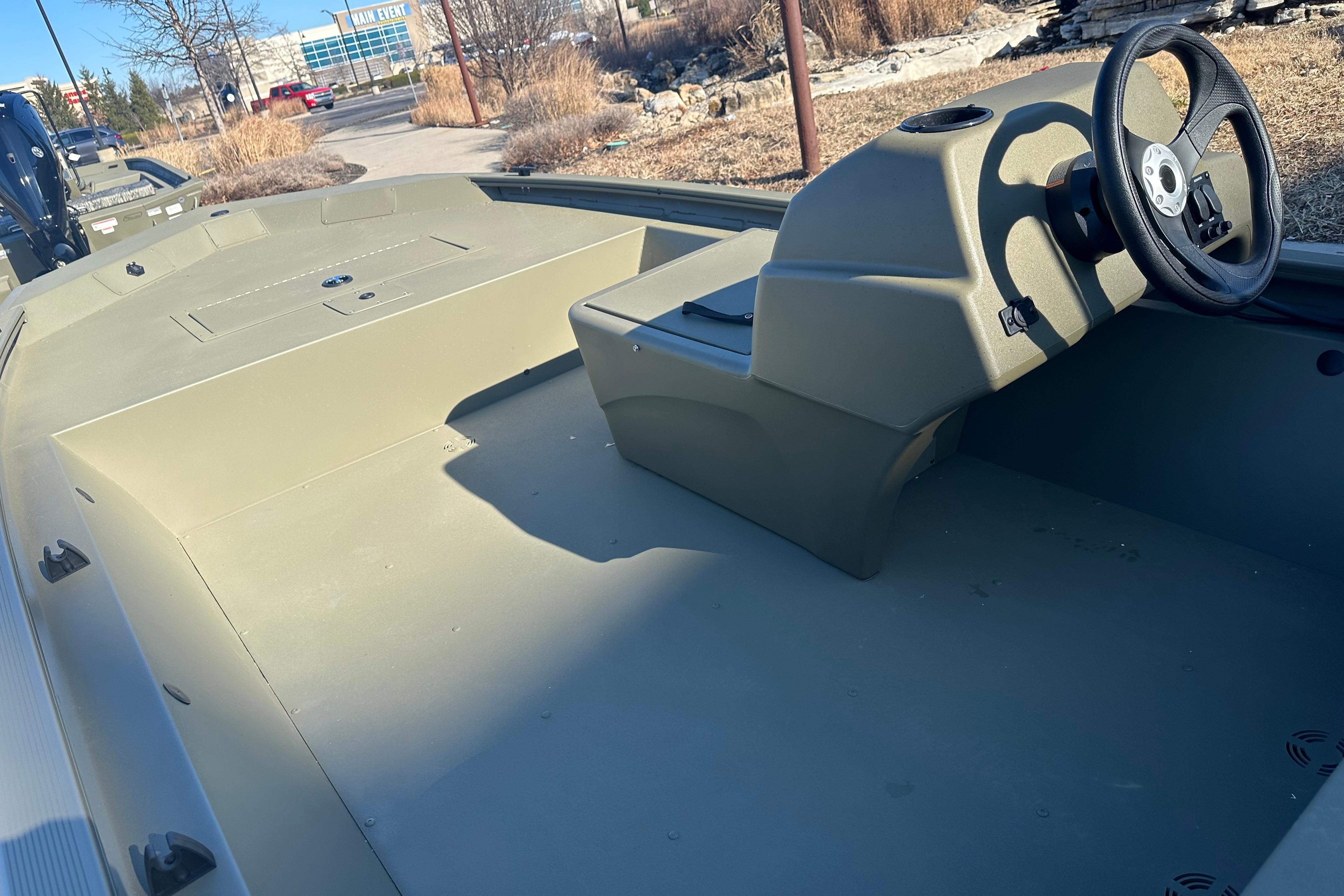 2026 Tracker Grizzly 1648 SC boat interior with steering console, outdoors in sunlight.