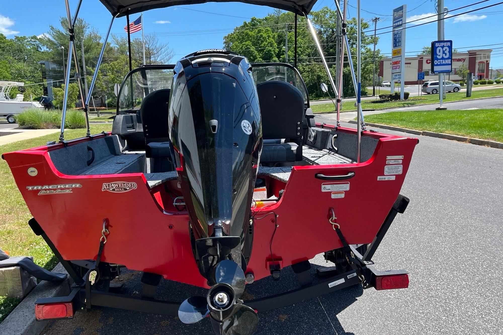 Red 2026 Tracker Pro Guide V-16 WT boat with outboard motor on a sunny day.