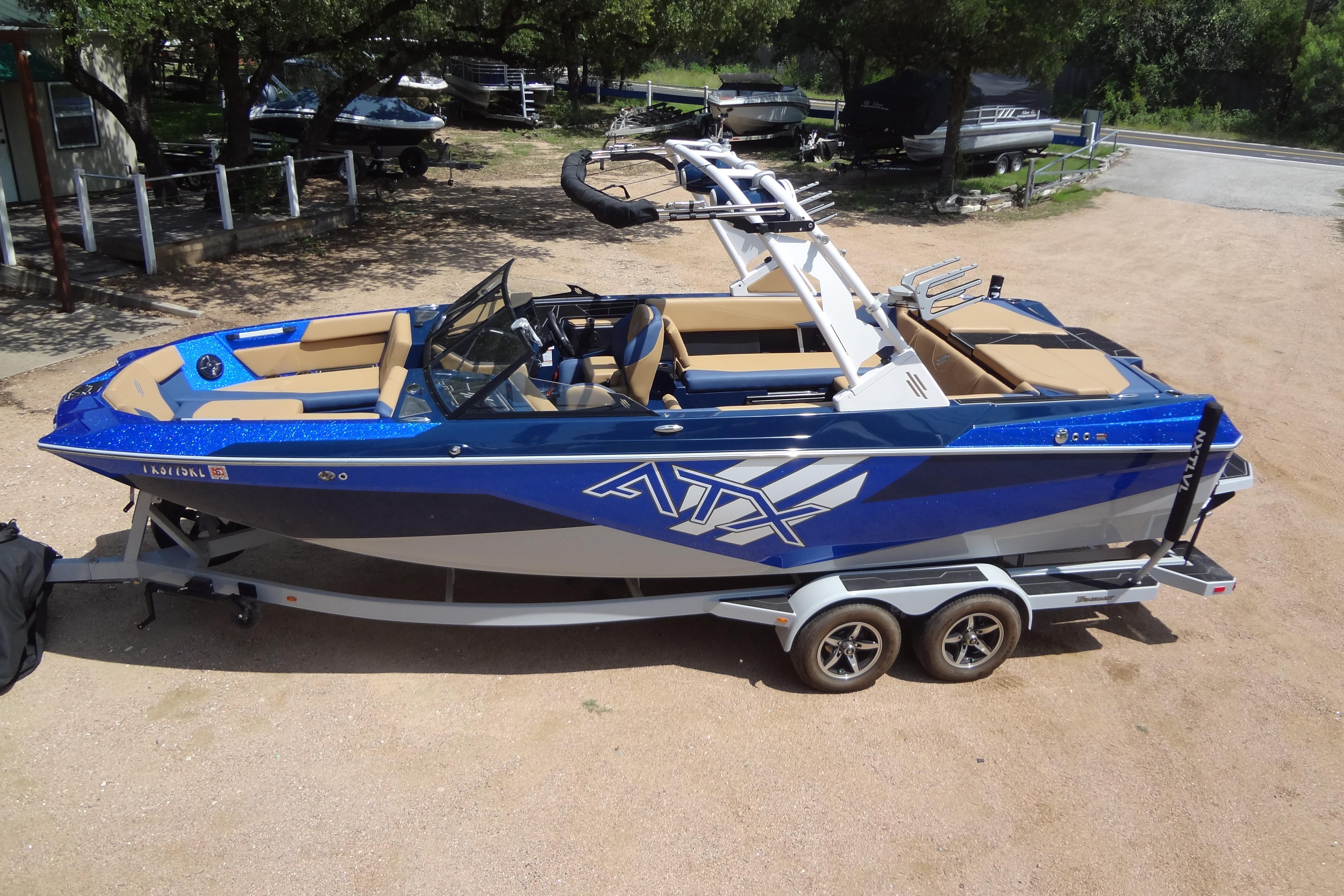 2022 ATX Surf Boats 24 Type-S on trailer, blue and tan design, parked outdoors.