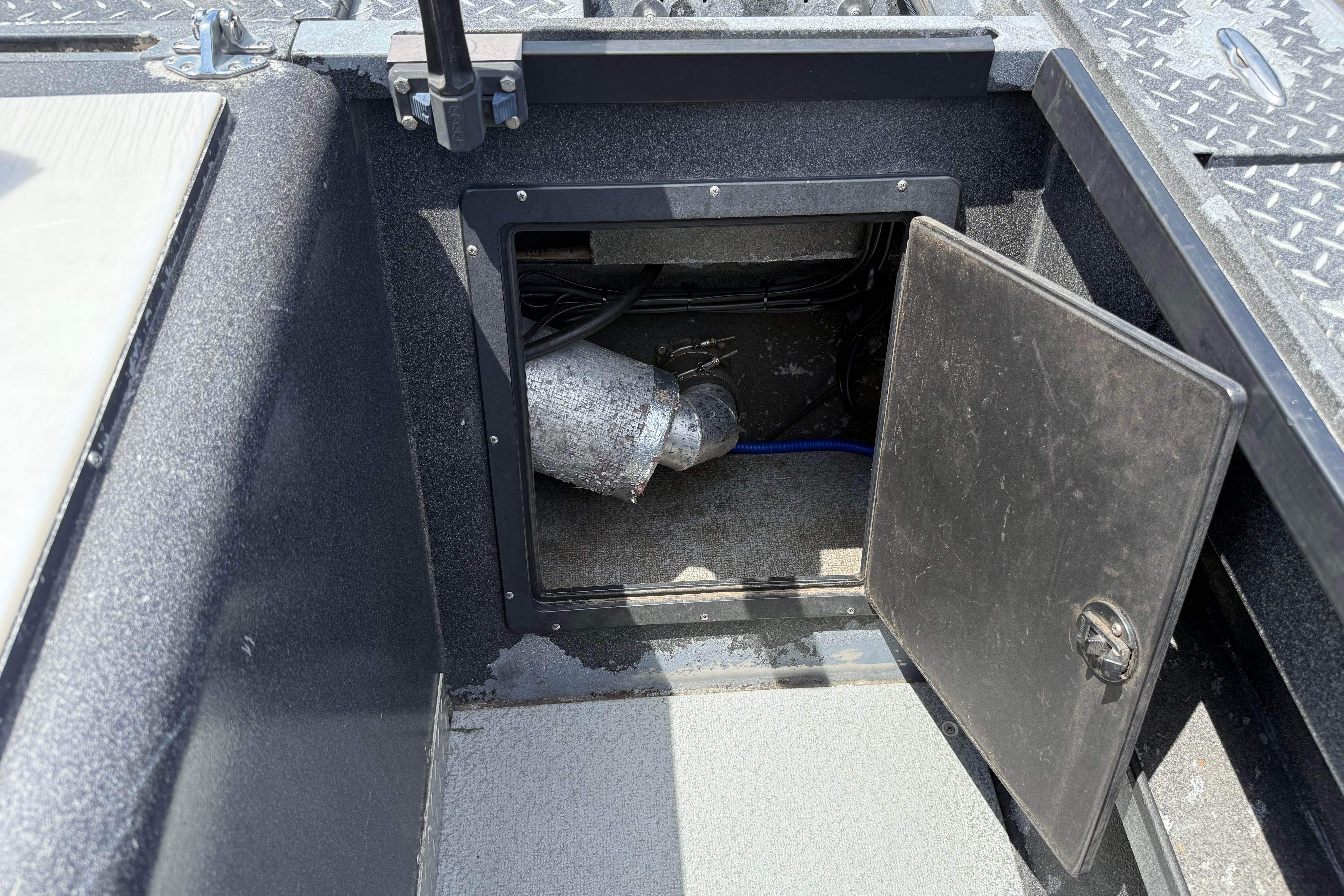 Open storage compartment in a 2005 Willie Raptor 21' boat, showing interior details.