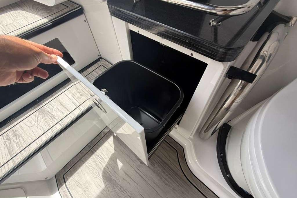 Hand opening storage compartment on 2026 Monterey Elite 30 OB boat.