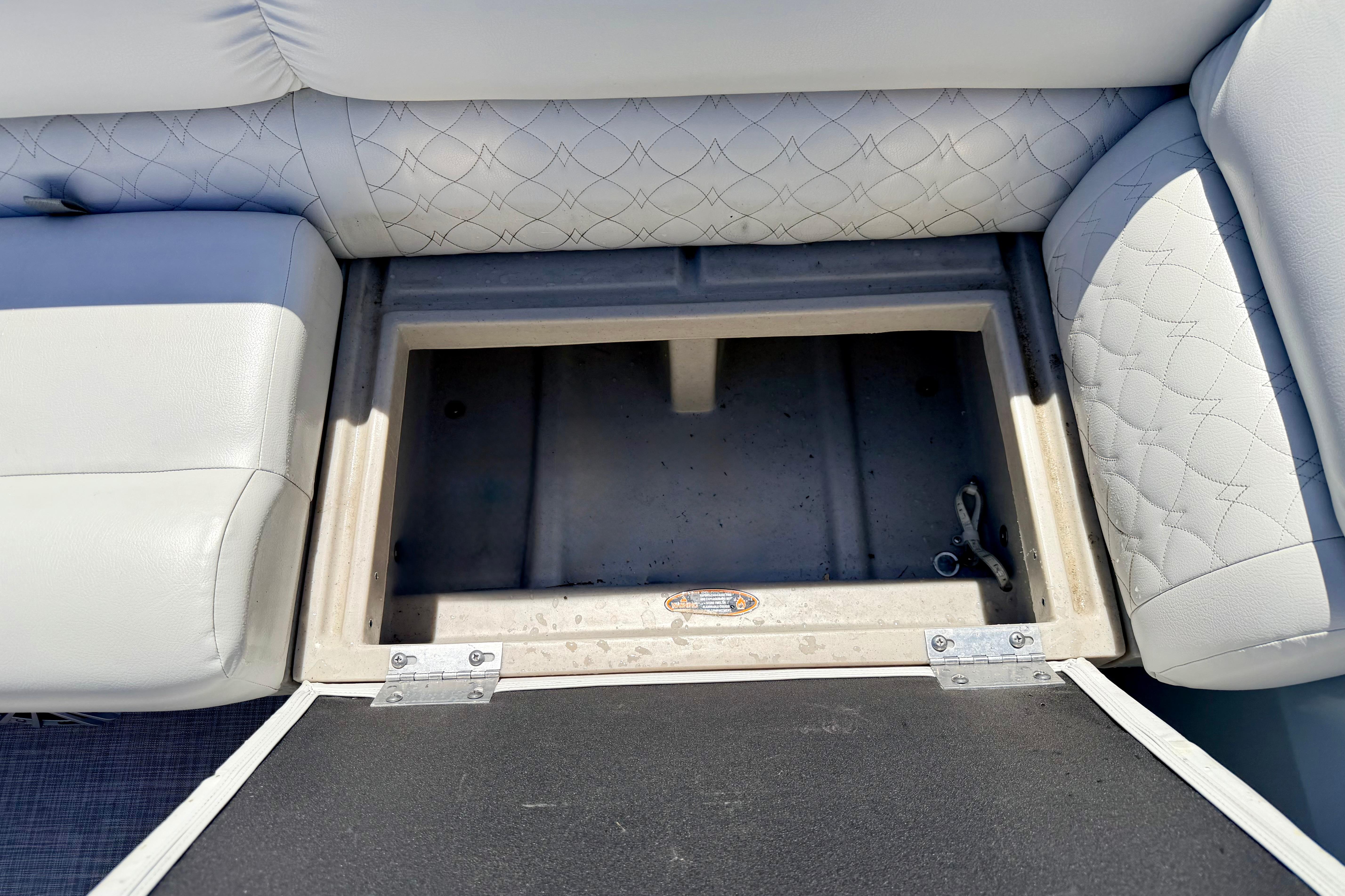 Open storage compartment in 2019 Crestliner 240 Rally DX CW boat with cushioned seating.