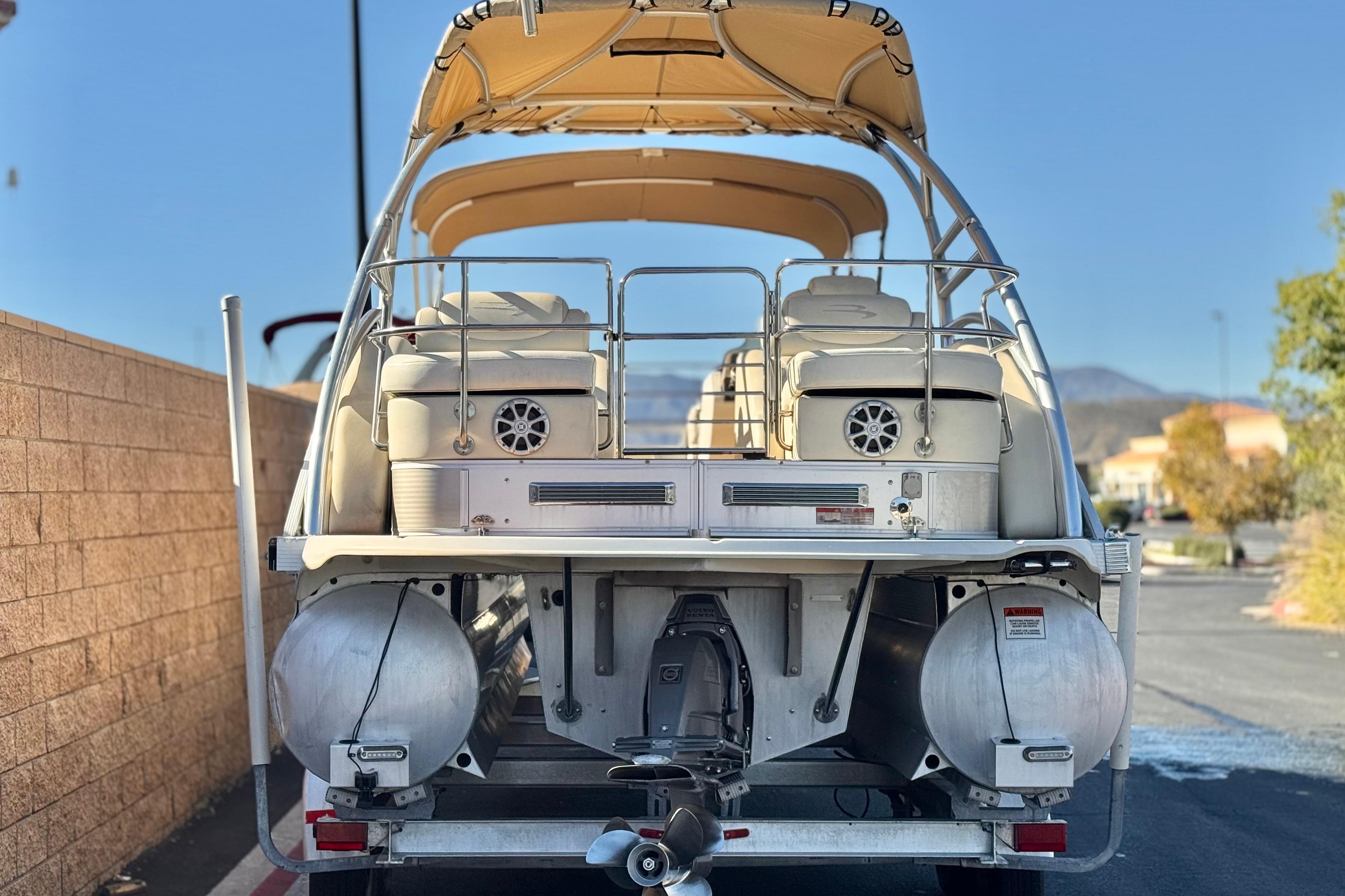 2013 Bennington 2575QCW I/O pontoon boat, rear view with canopy and seating.