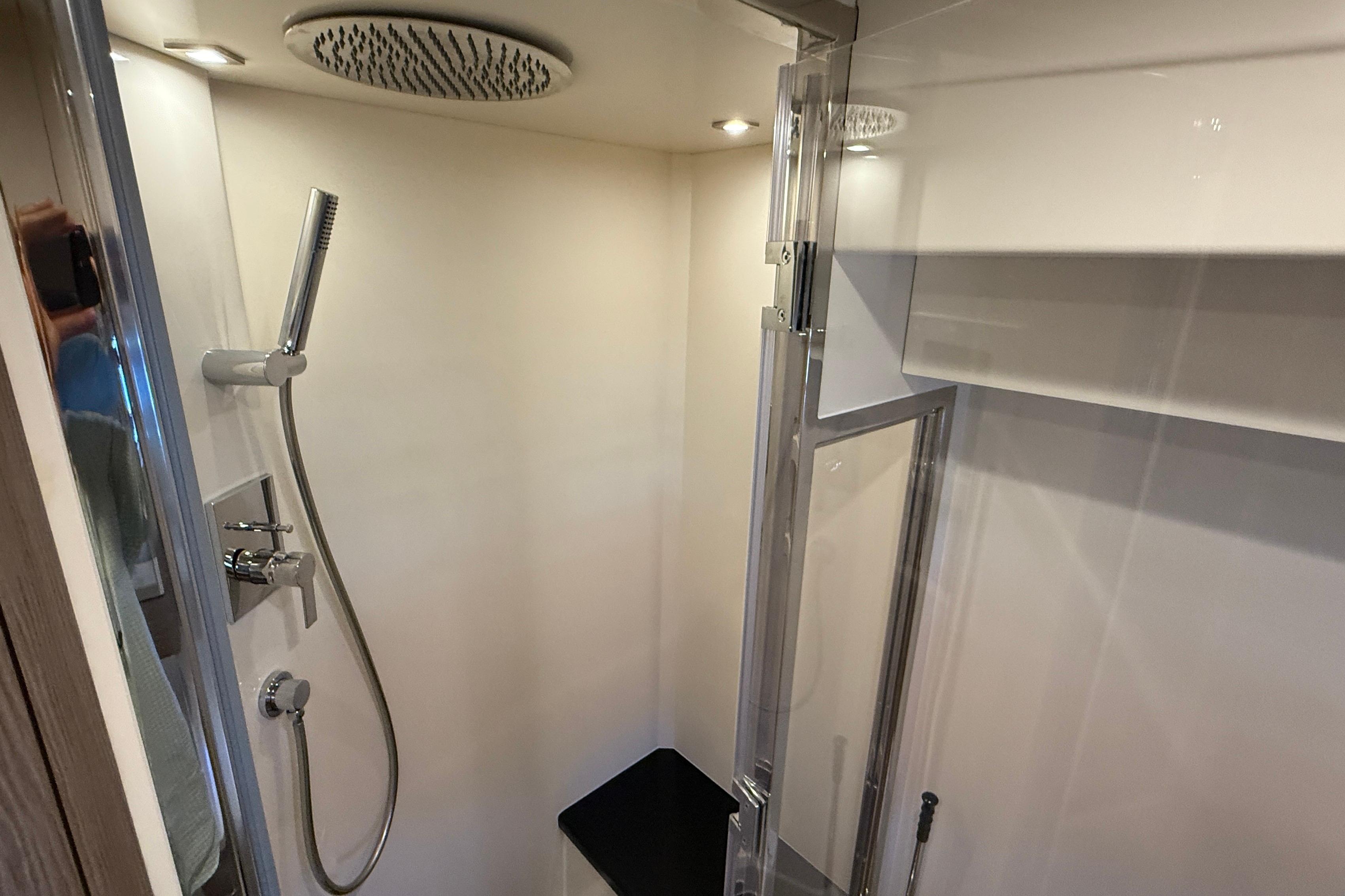 Modern shower in 2022 Sirena 58 yacht with rainfall showerhead and sleek design.