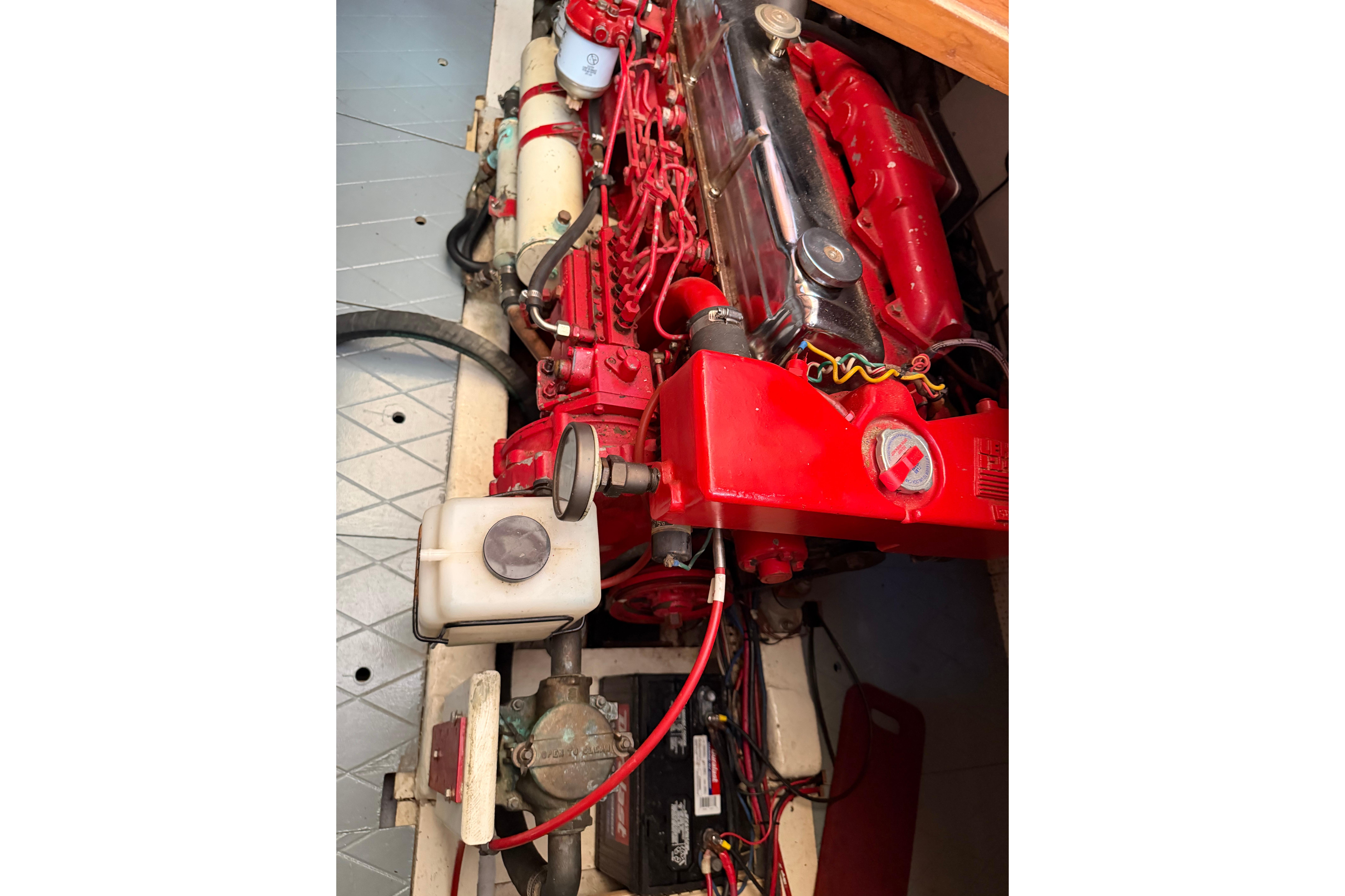 Engine compartment of a 1987 Marine Trader 36, featuring a red engine and components.