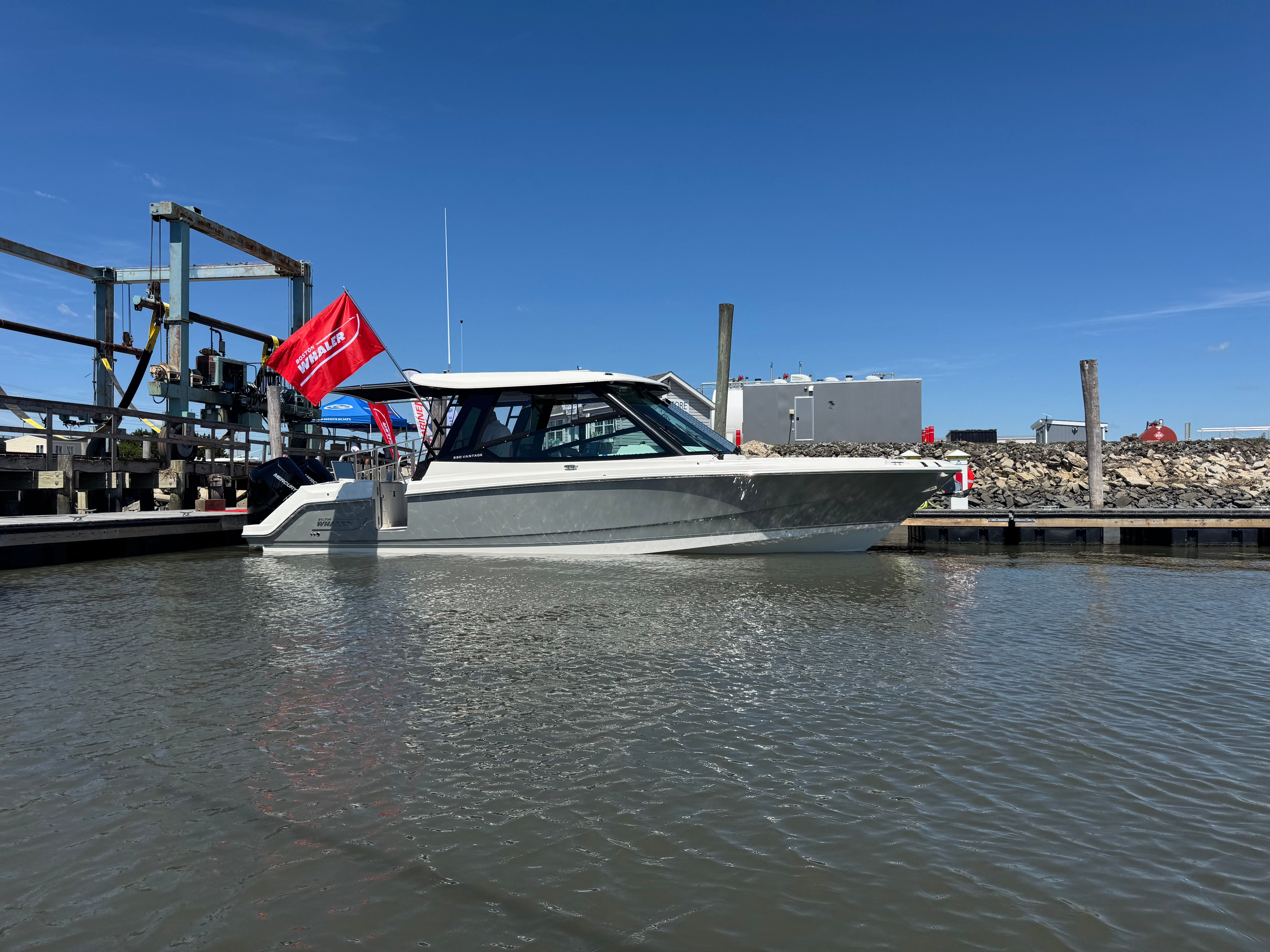A 2025 Boston Whaler 330 Vantage is docked on the water.