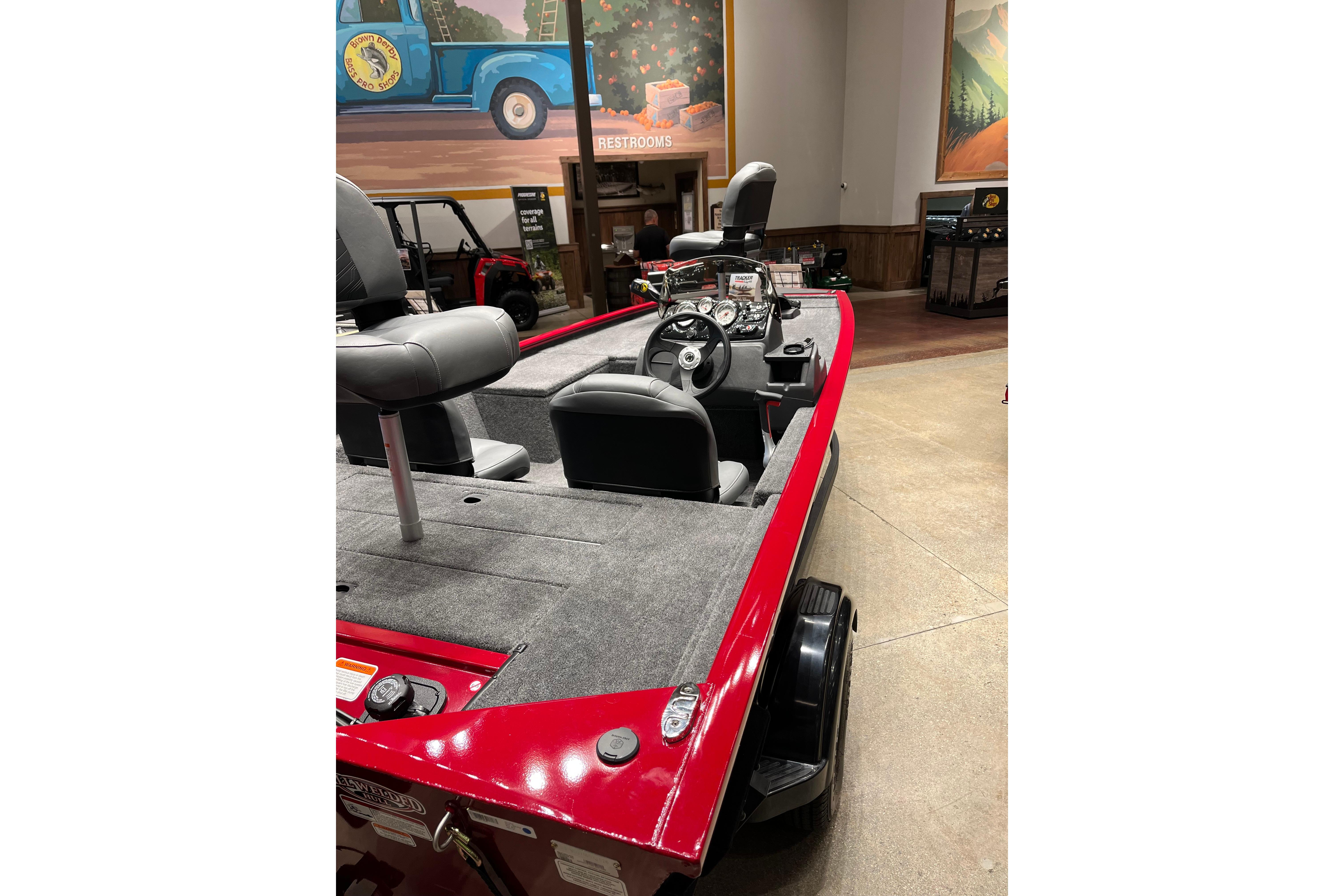 2026 Tracker Pro 170 boat with red exterior and gray interior, displayed indoors.