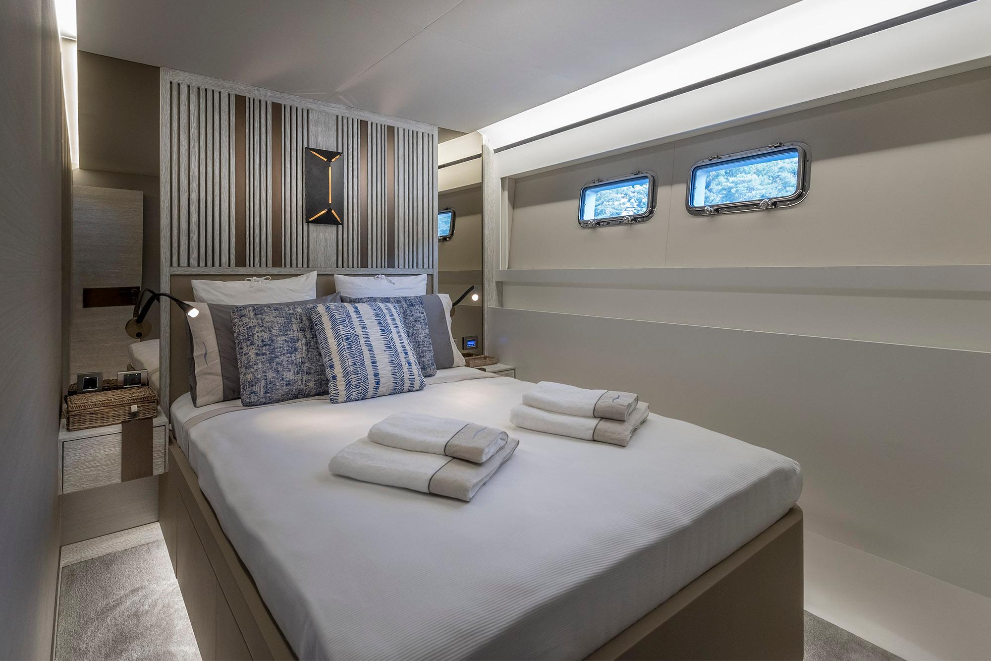 Luxurious bedroom interior of 2025 Numarine 26XP yacht with modern design and cozy bedding.