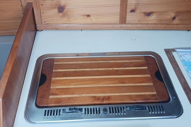 1989 O'Day 272 sailboat interior with wooden countertop and built-in stove.