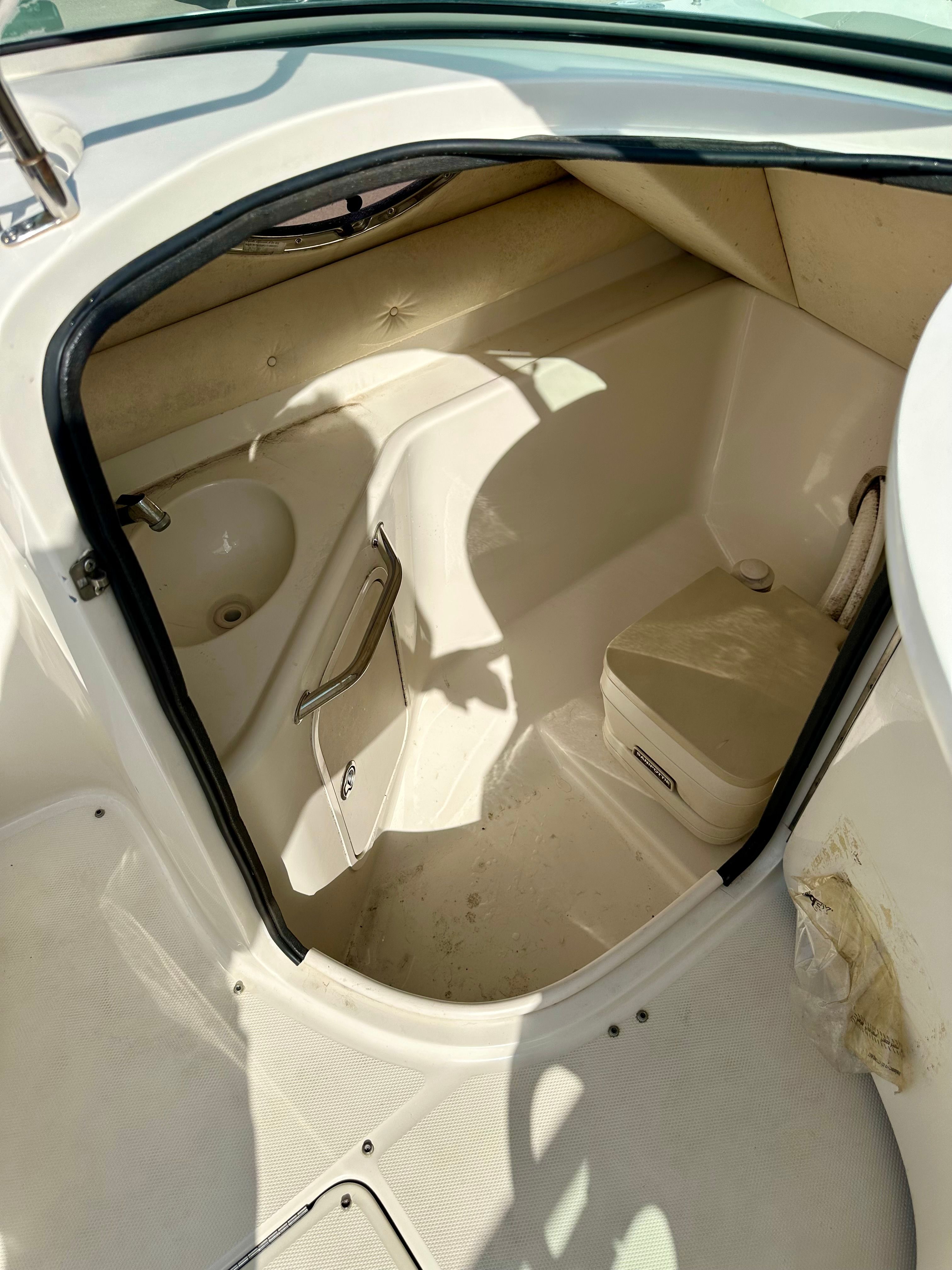 Interior of a 2006 Sea Ray 240 Sundeck with sink and toilet.