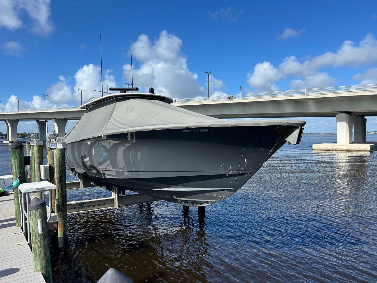 2020 Valhalla Boatworks 41 on lift, docked near bridge under blue sky.