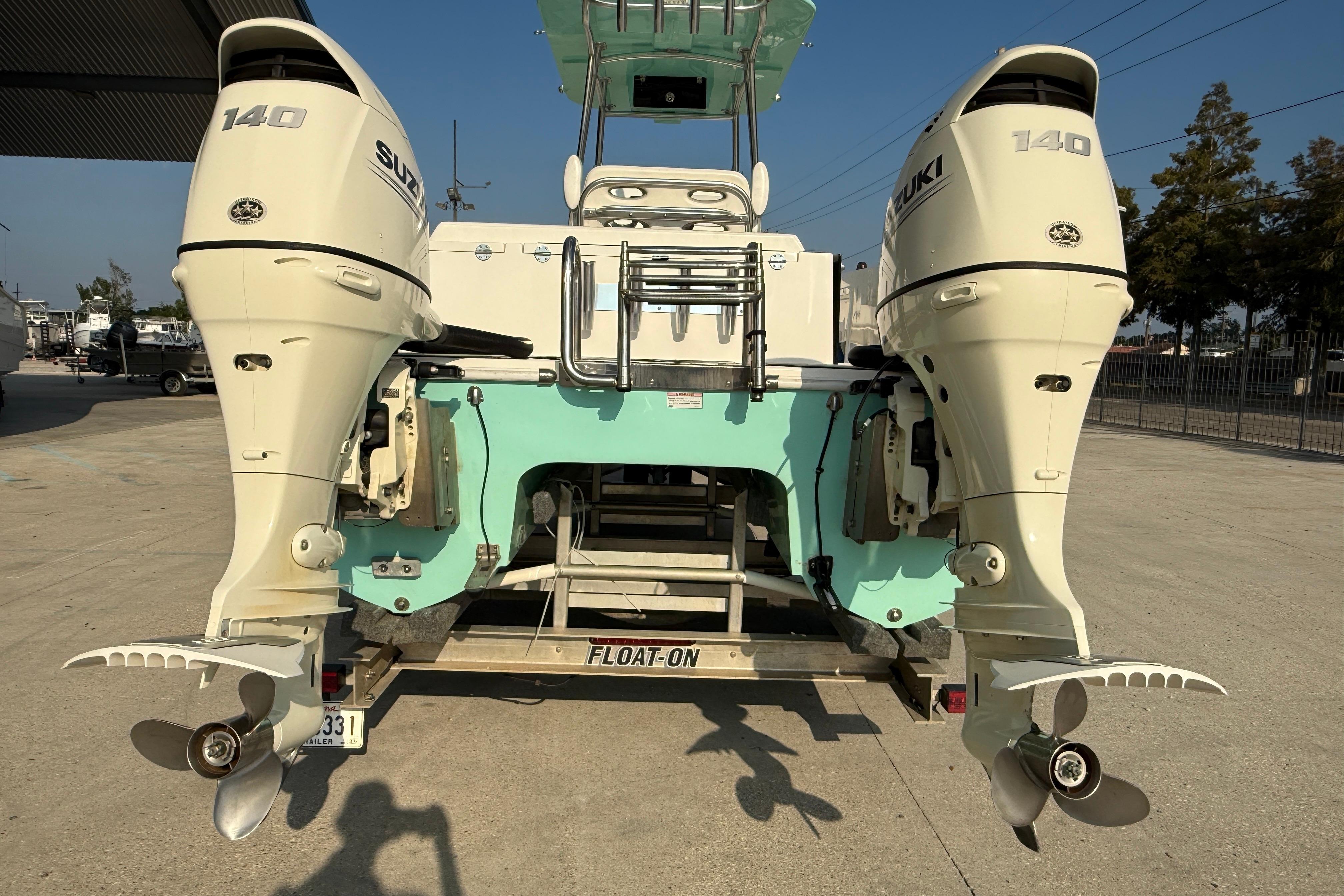 2020 Twin Vee 240 GFX CC boat with dual Suzuki 140 outboard engines on a trailer.