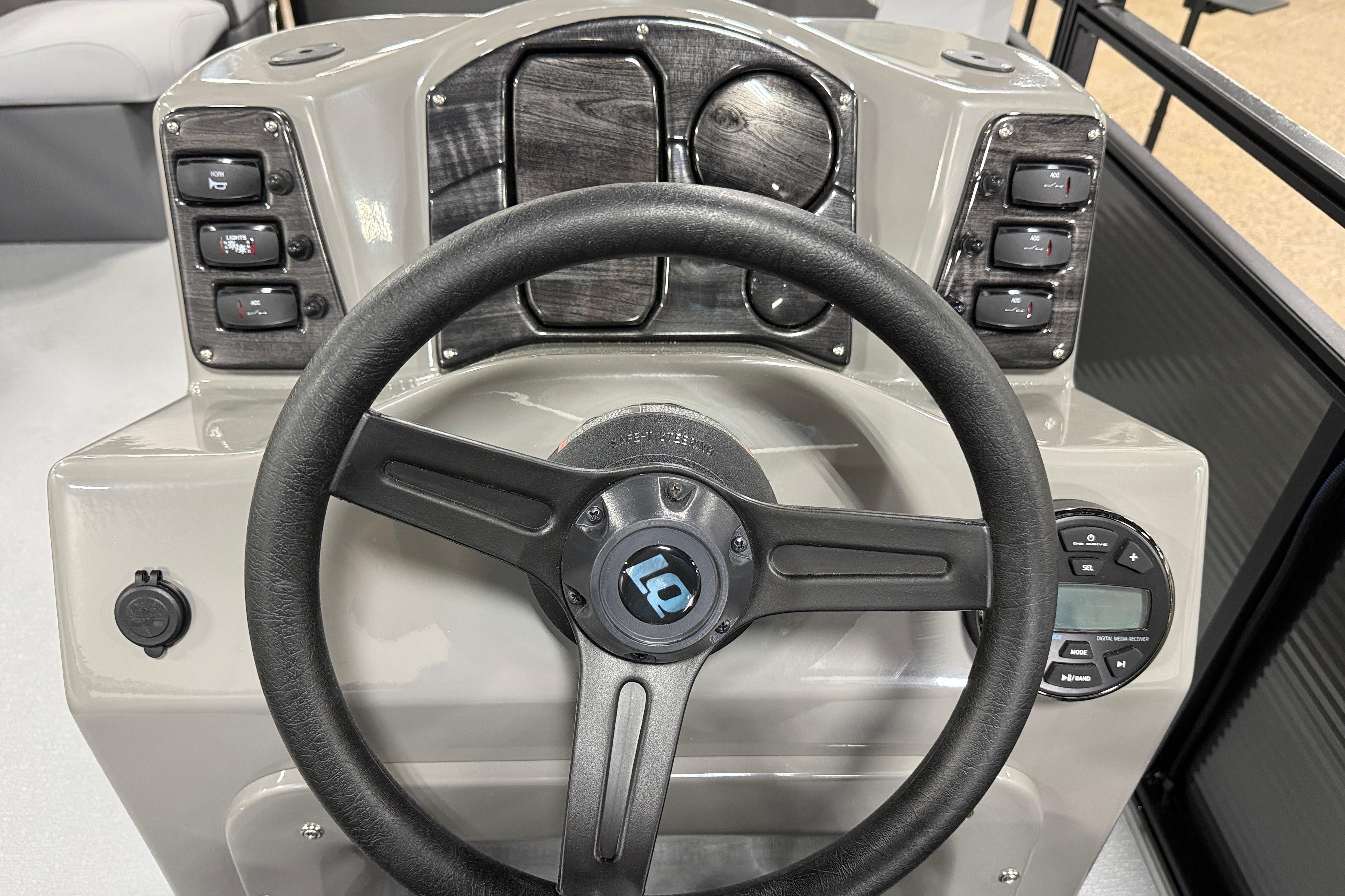 Steering console of 2026 Angler Quest 7515 Leisure Quest Cruise boat, featuring control panel and switches.