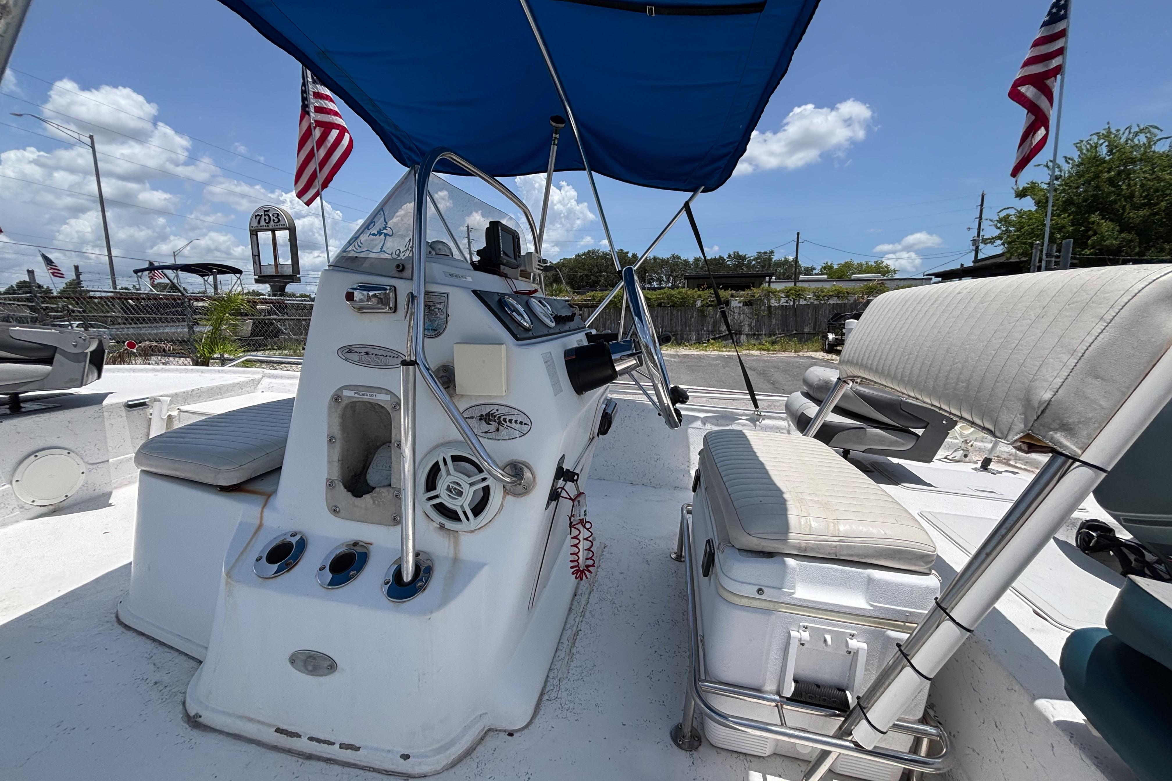 2000 VIP 1880 BAY STEALTH boat interior with steering console and seating under blue canopy.