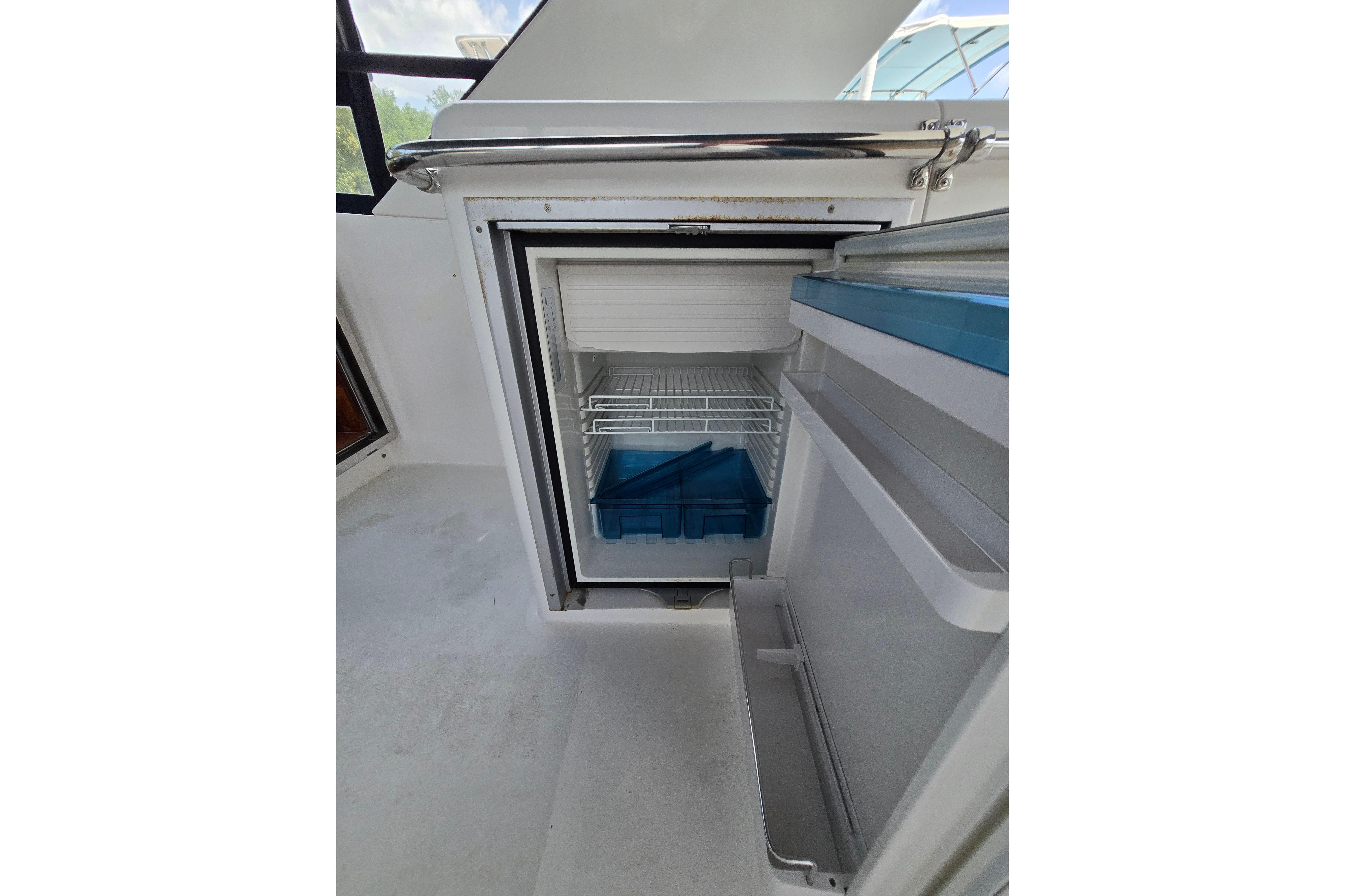 Open refrigerator on 2004 Grand Harbour 58 yacht, showcasing interior shelves and storage.