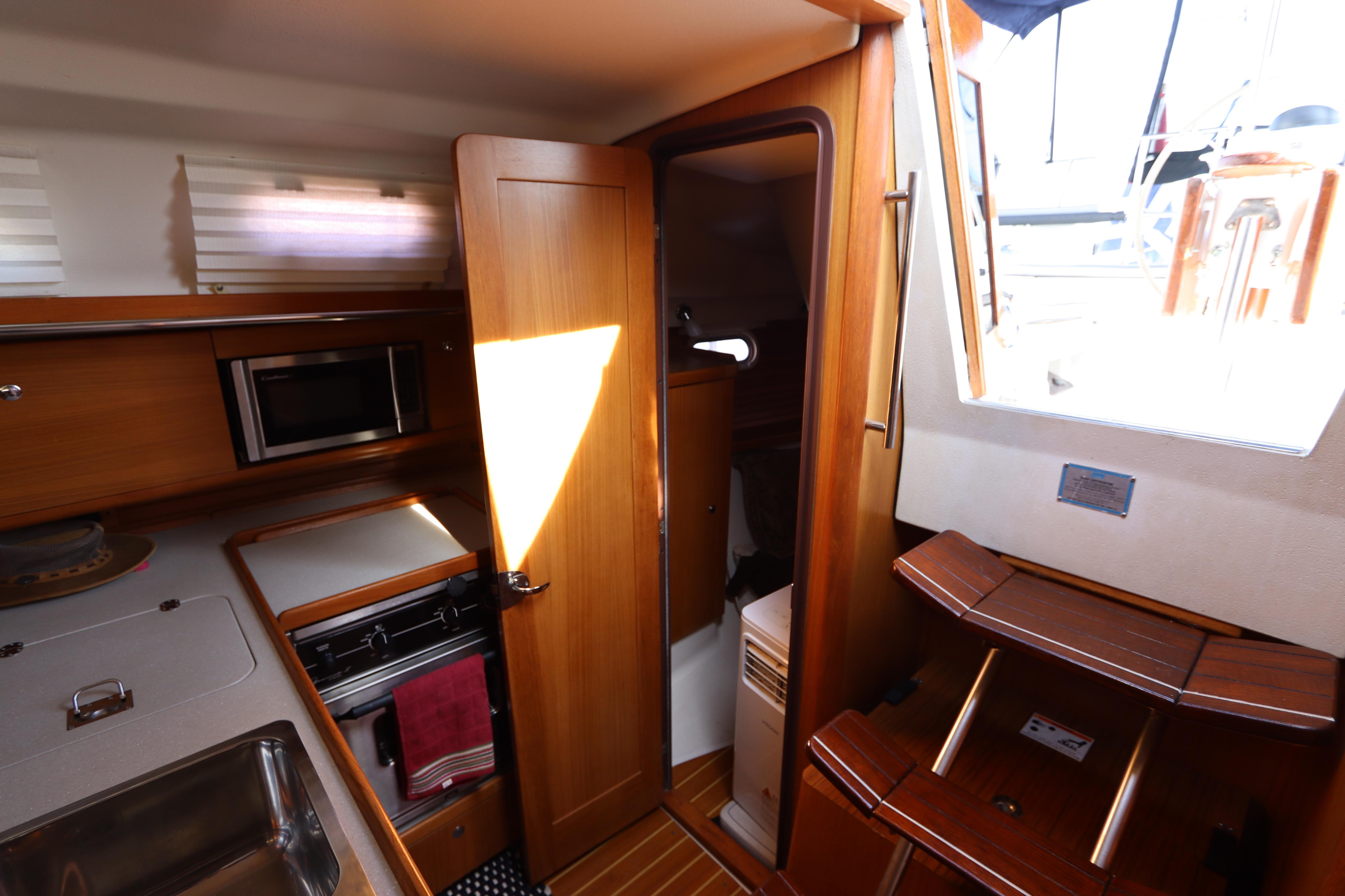 Interior of 2011 Catalina 355 sailboat with kitchen and wooden cabinetry.