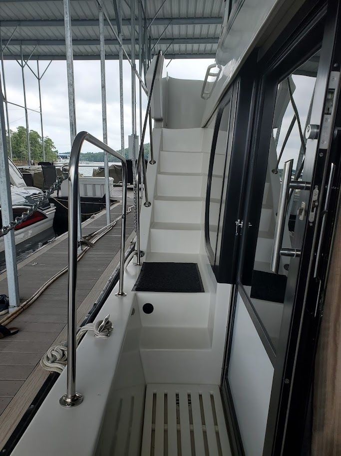 1996 Blue Water Motor Yacht with stairs and railing in marina.