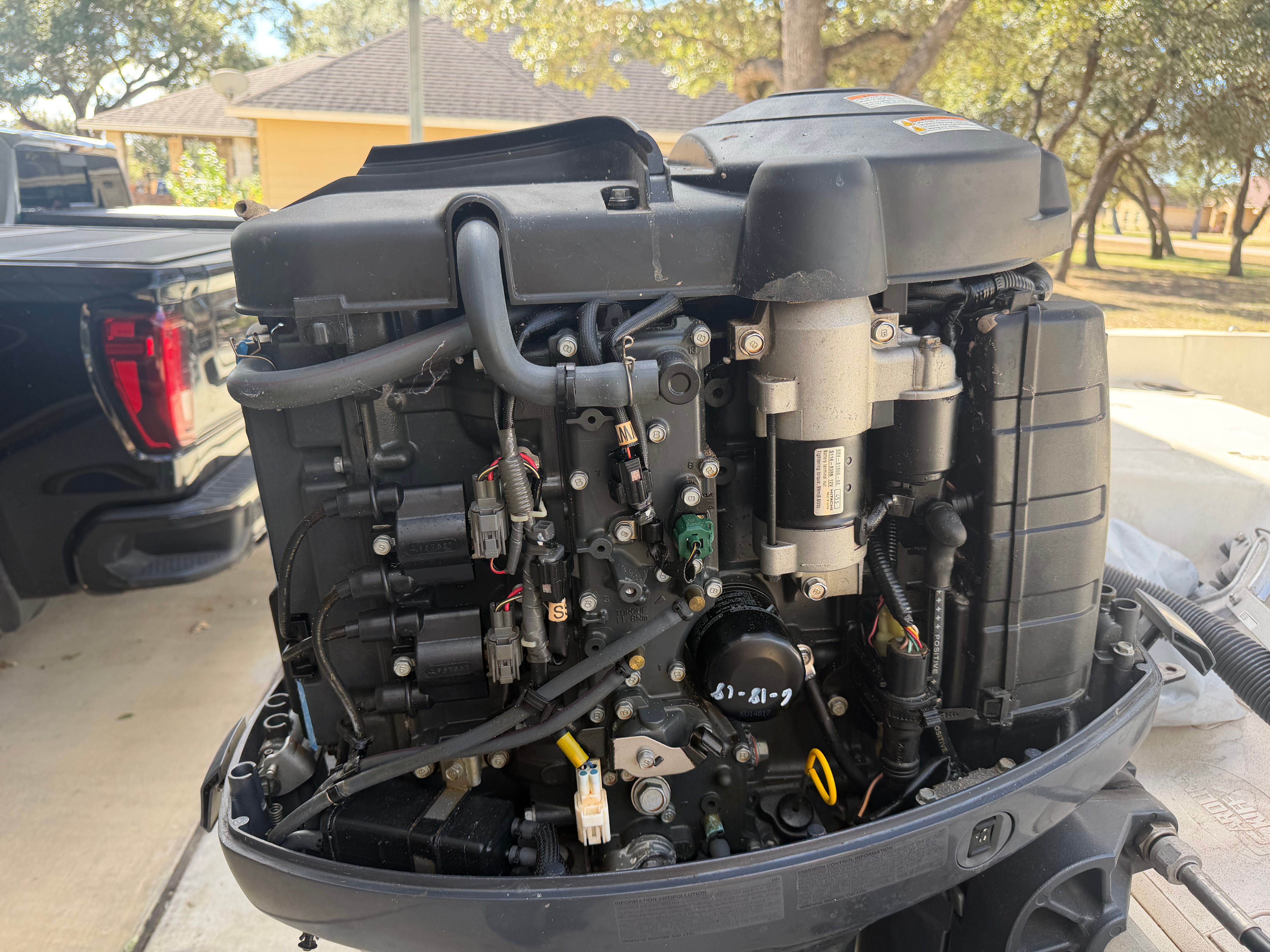 Close-up of a boat outboard motor with exposed wires and components.