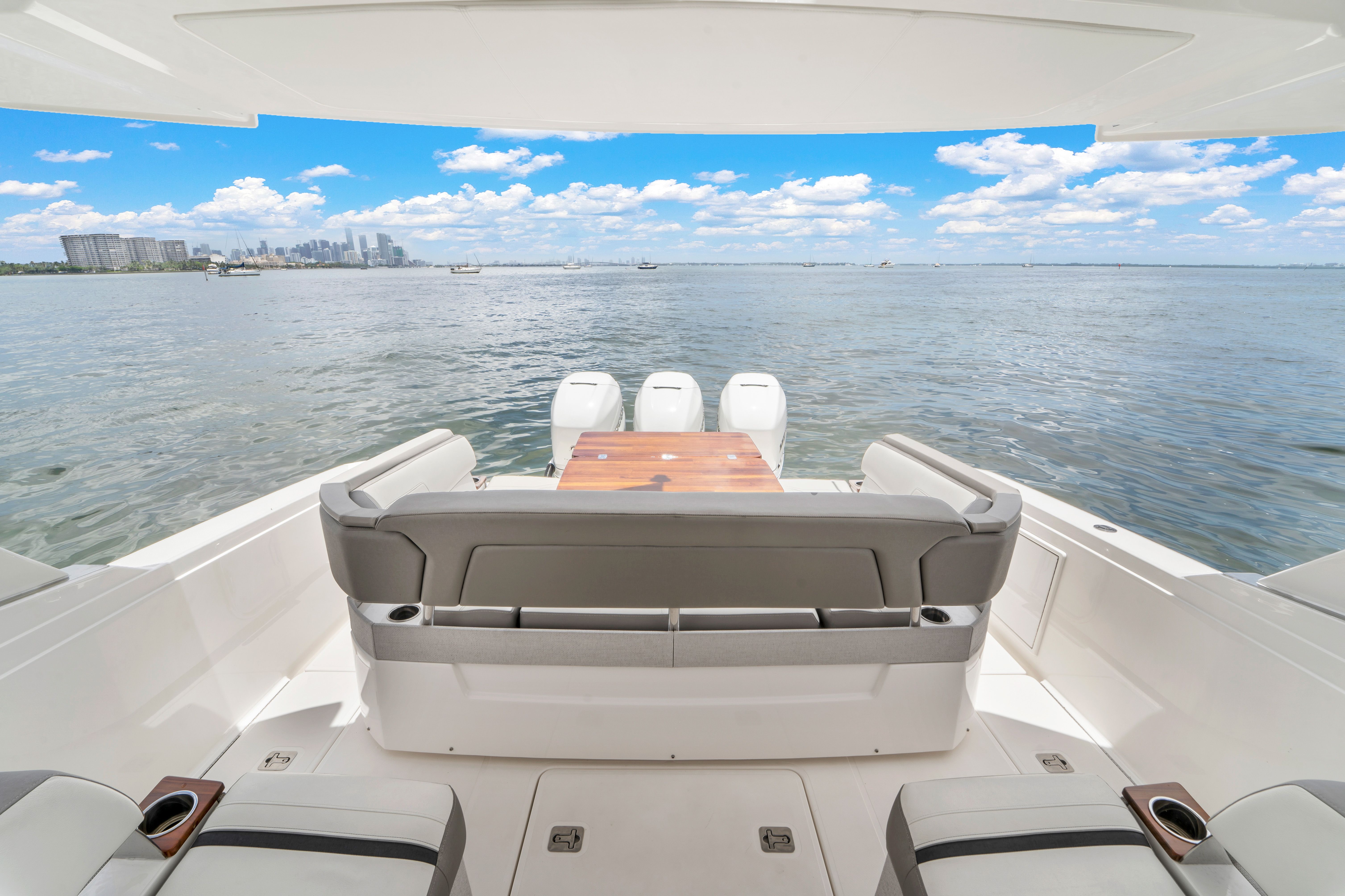 The image shows the stern of a 2023 Tiara Yachts 38 LS overlooking the water.